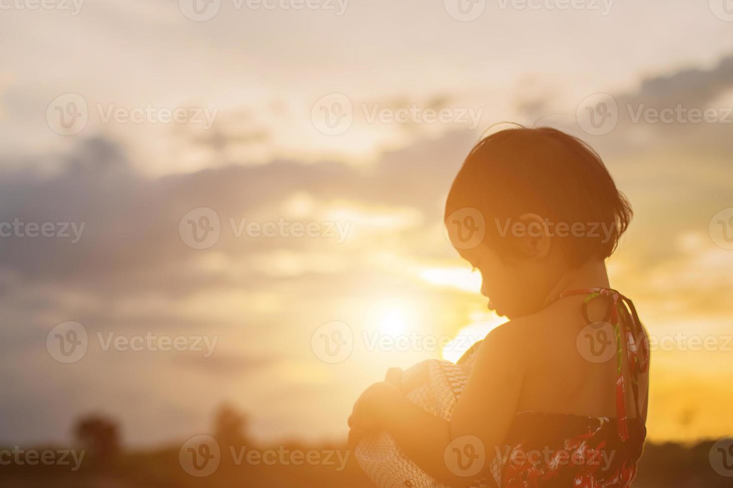 silhouette d'enfant, moments de joie de l'enfant. sur le coucher de soleil nature photo