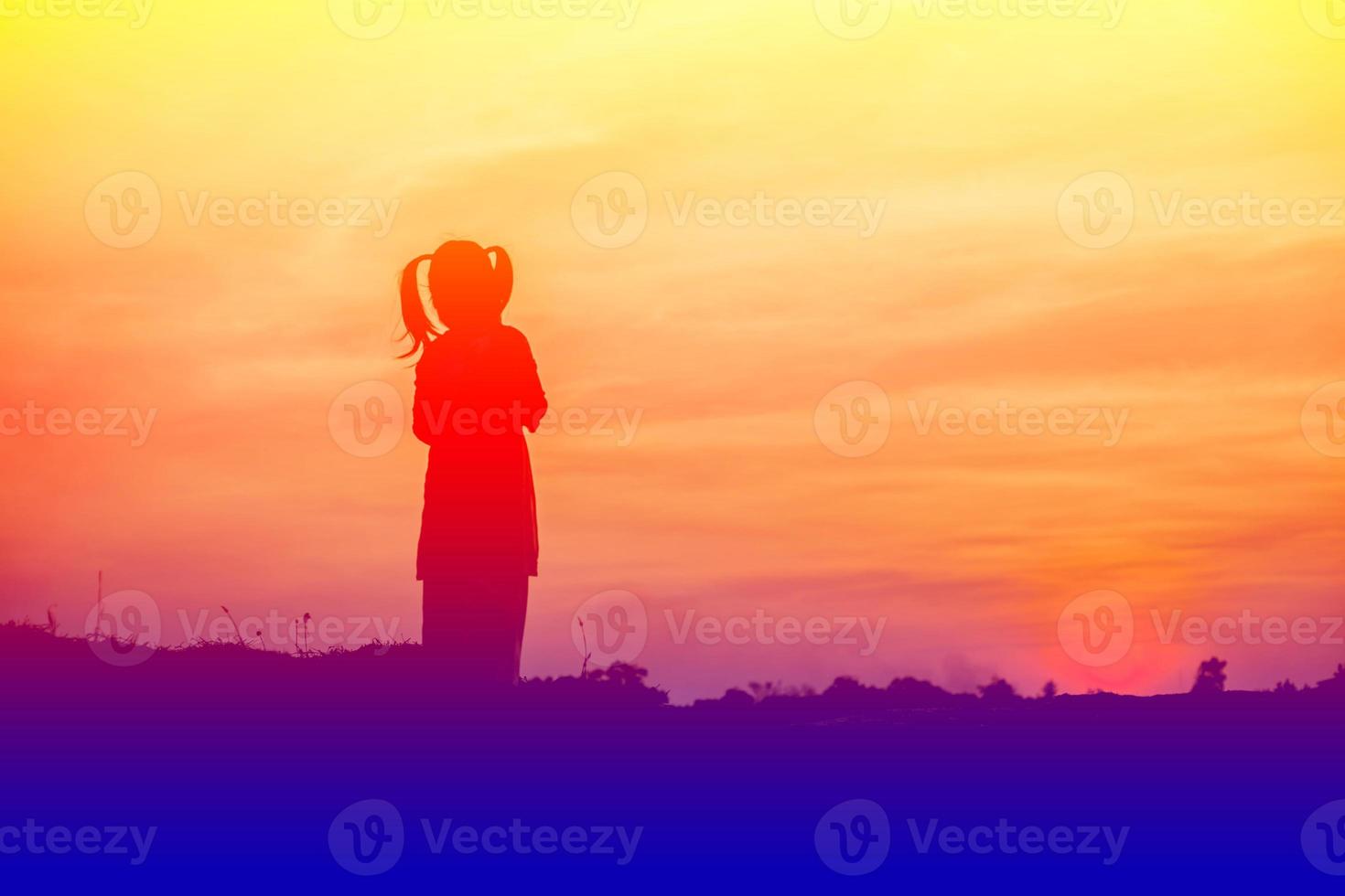 silhouette d'enfant, moments de joie de l'enfant. sur le coucher de soleil nature photo
