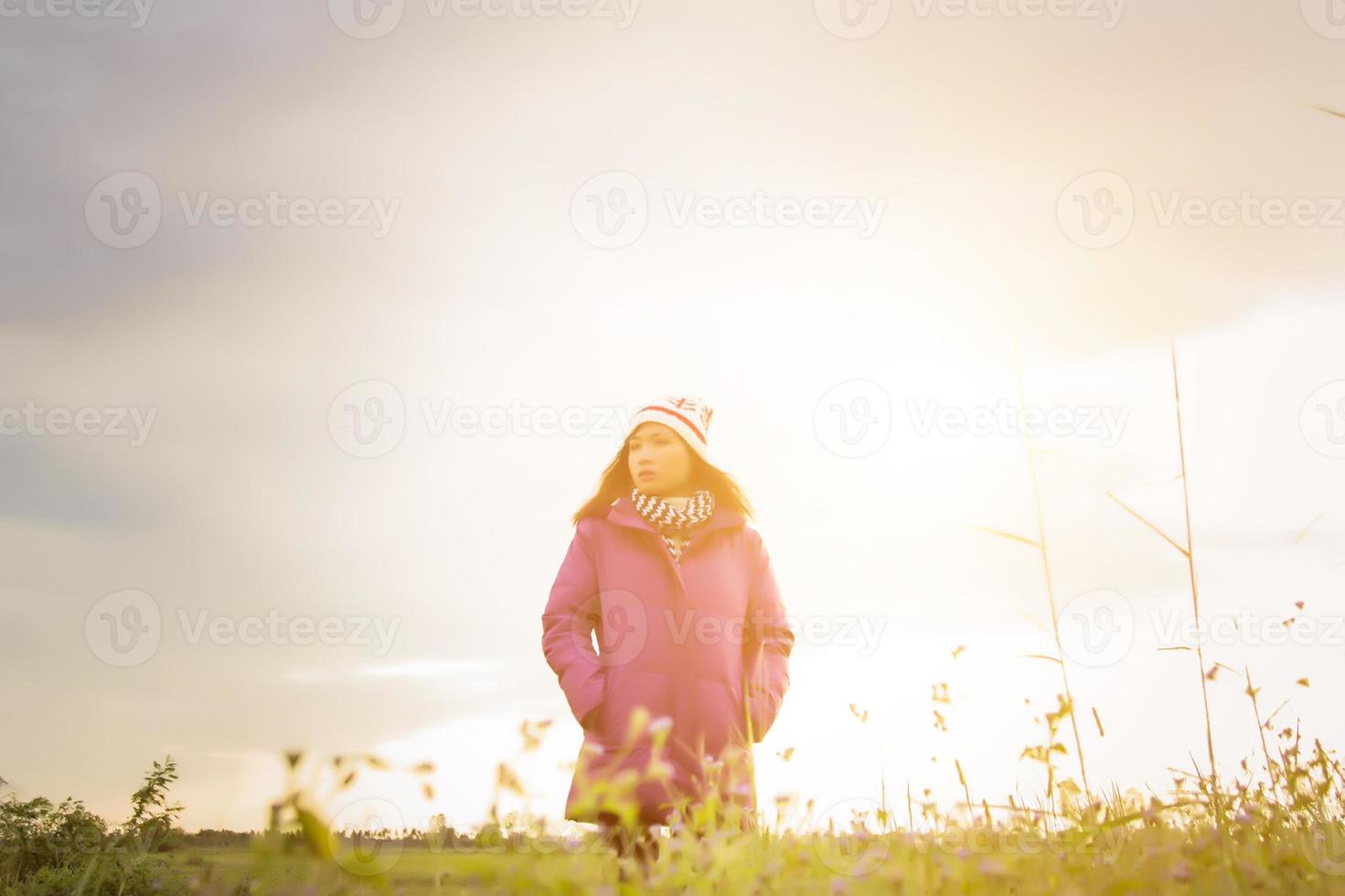 jeune femme jouait dans un champ de fleurs dans l'air hivernal. photo