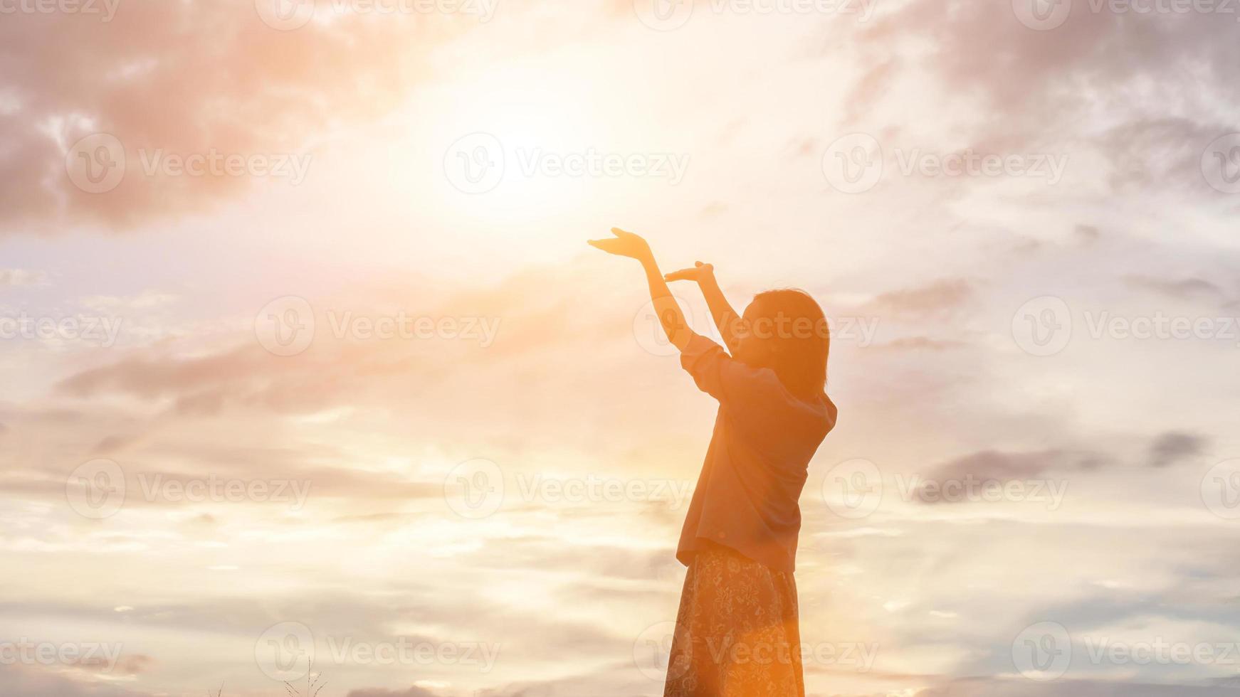 silhouette de femme priant sur fond de ciel magnifique photo