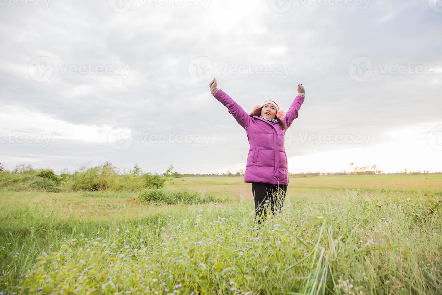 jeune femme jouait dans un champ de fleurs dans l'air hivernal. photo