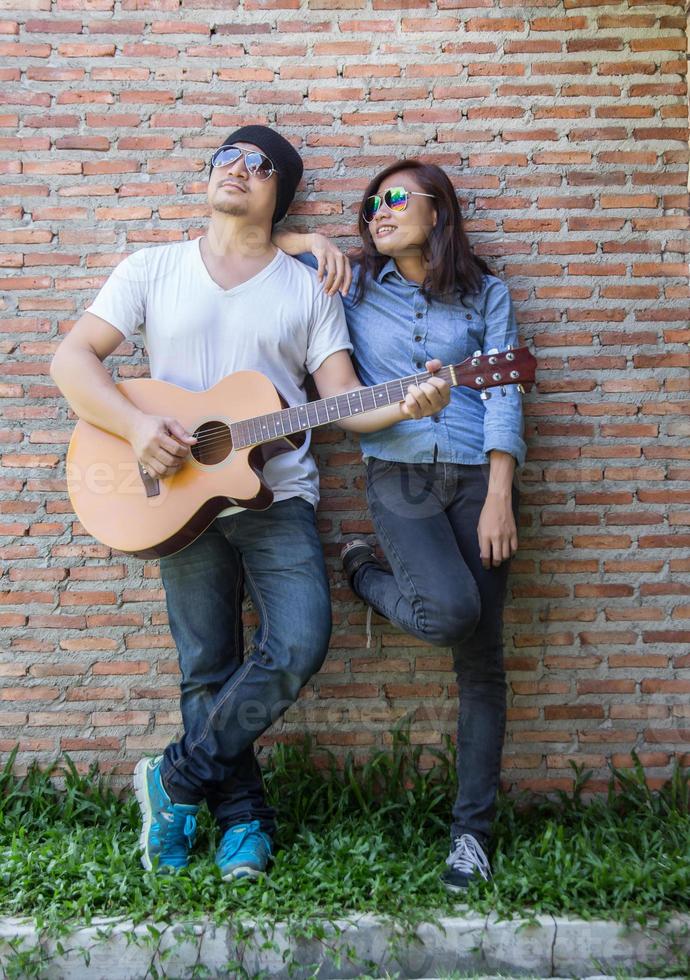 jeune homme hipster jouant de la guitare pour se détendre pendant ses vacances, profiter de l'air naturel et frais. photo