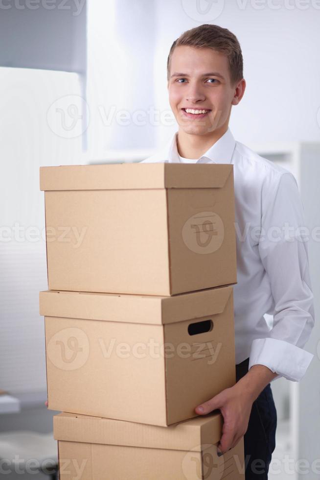 jeune homme tenant une pile de boîtes en carton debout dans photo