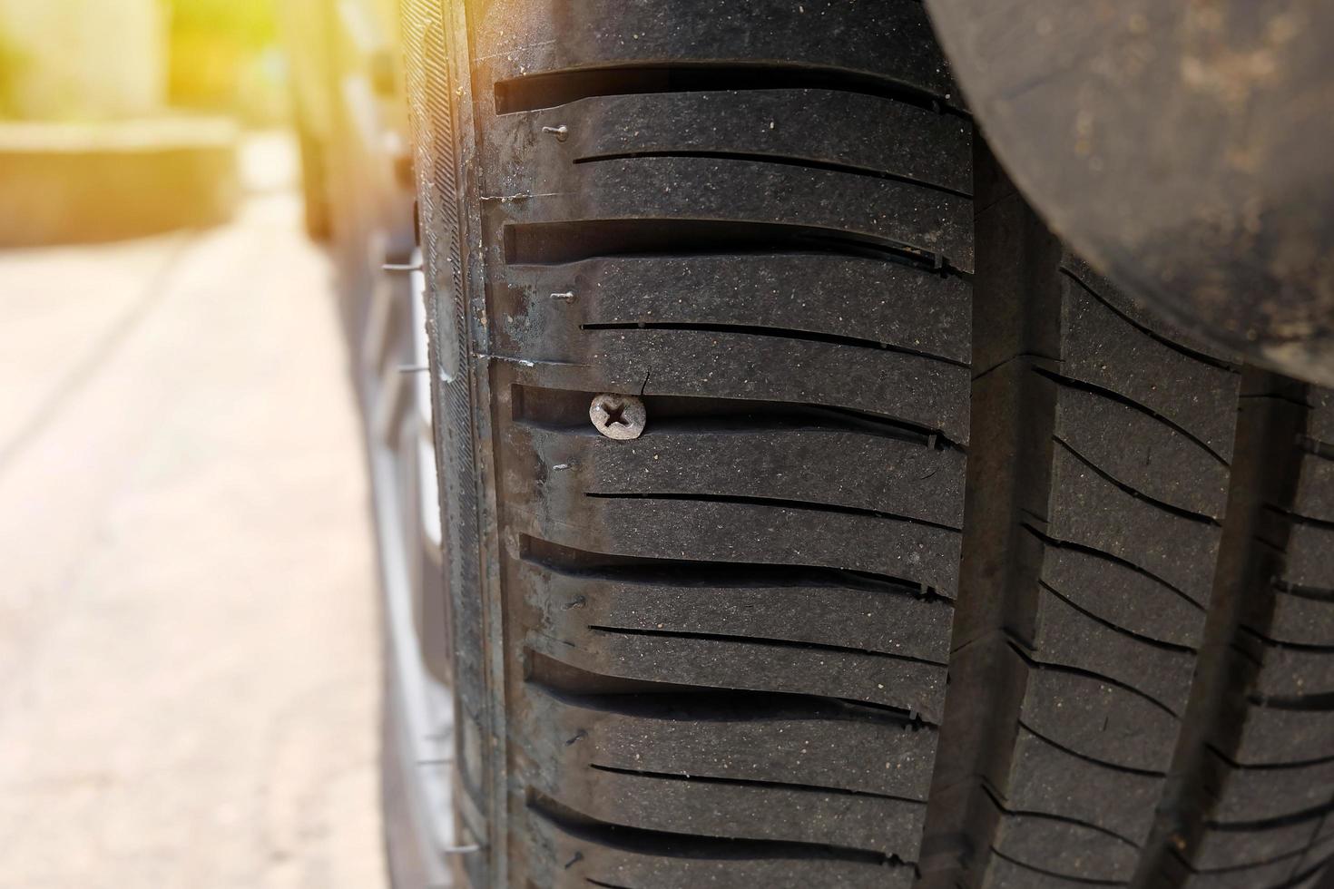 problème avec une roue de voiture. une voiture a heurté un clou sur la route, photo