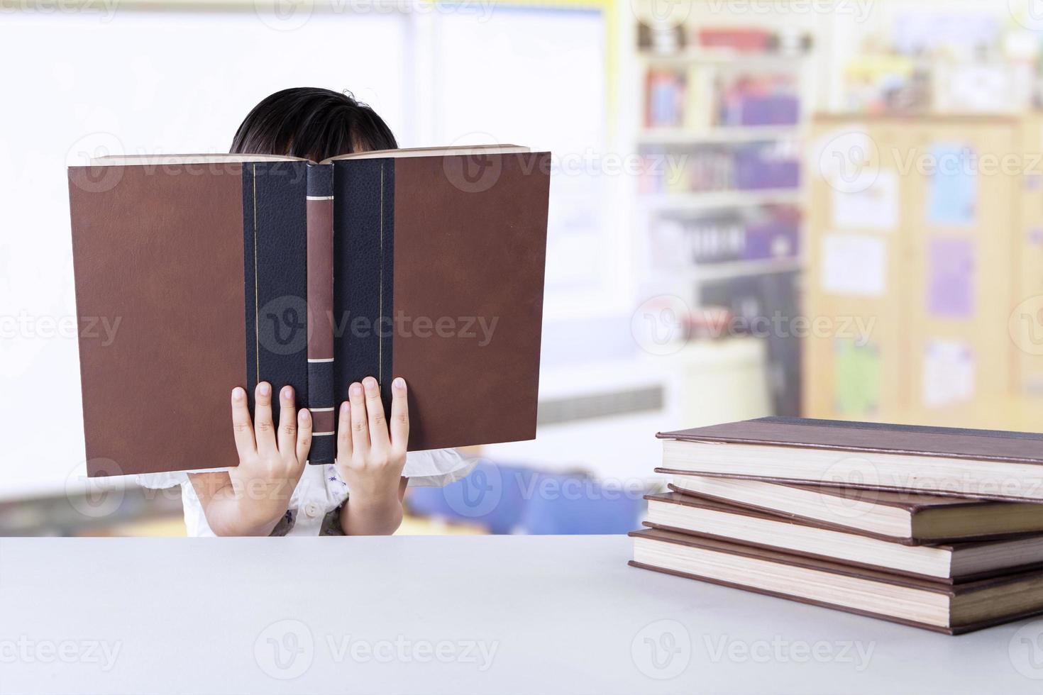 petite étudiante lit des livres en classe photo