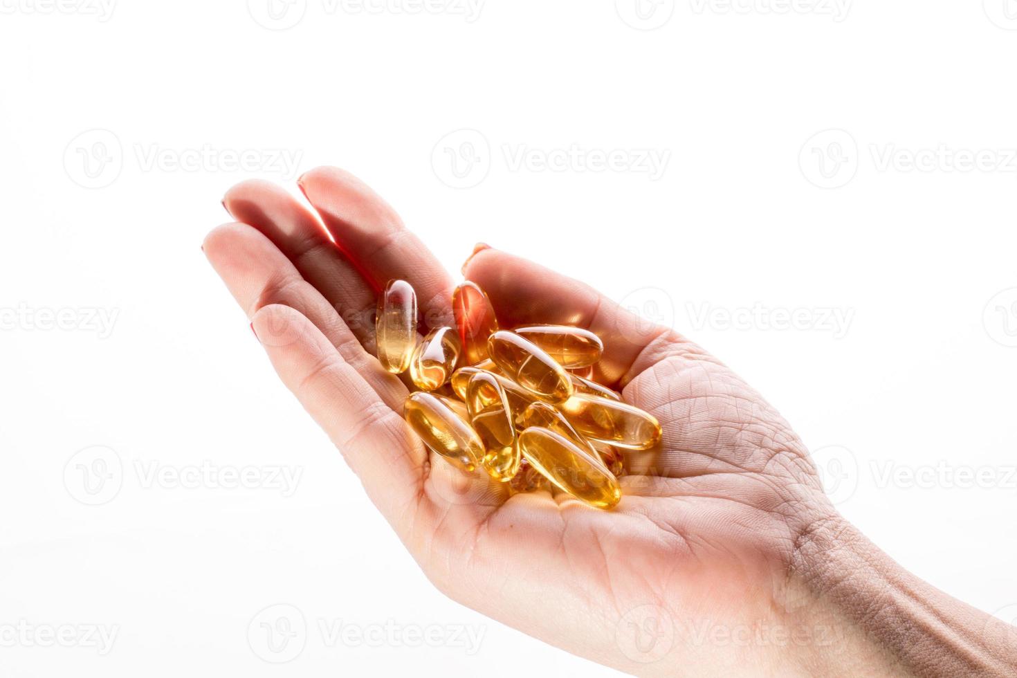 main féminine avec des capsules de pilules sur fond blanc photo