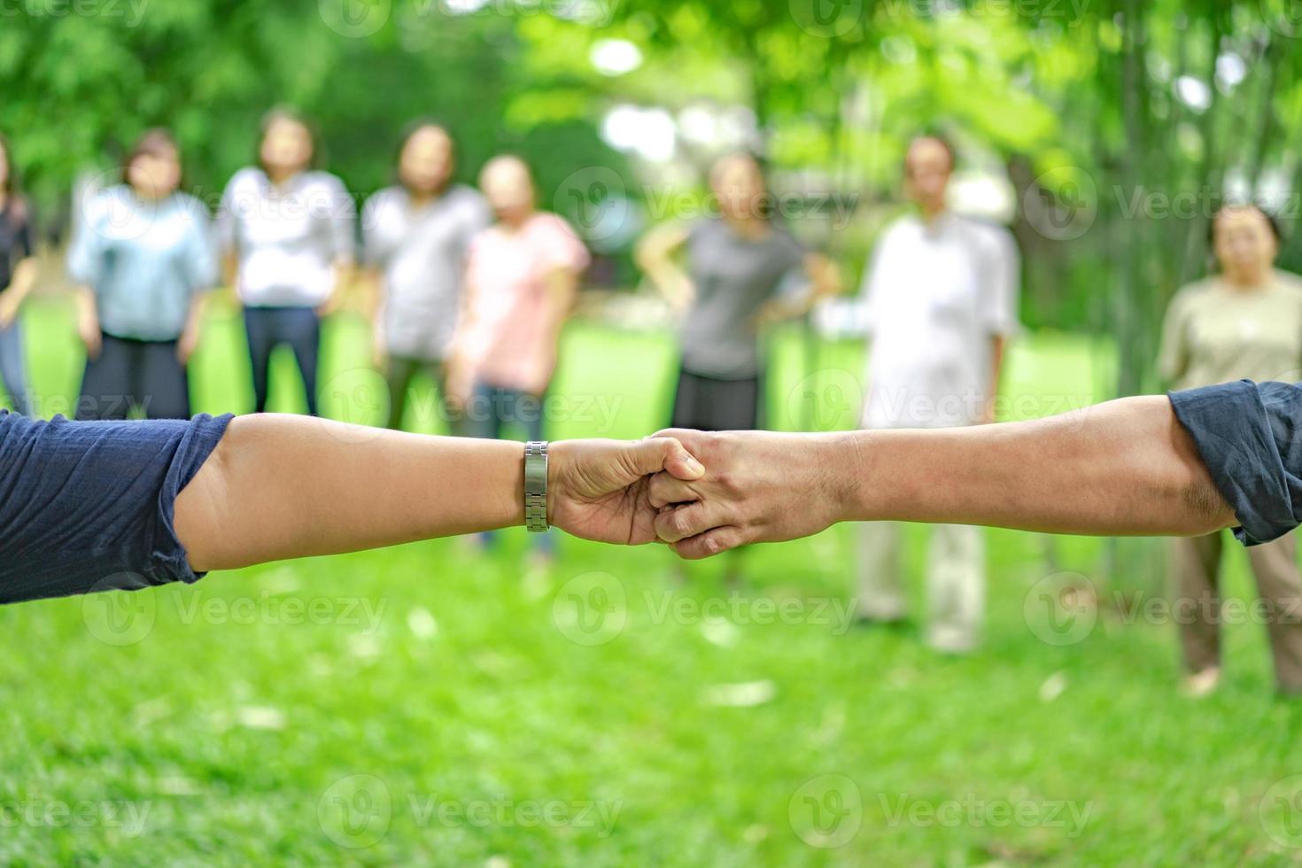 la main tient ensemble dans la communauté dans le parc du jardin. photo