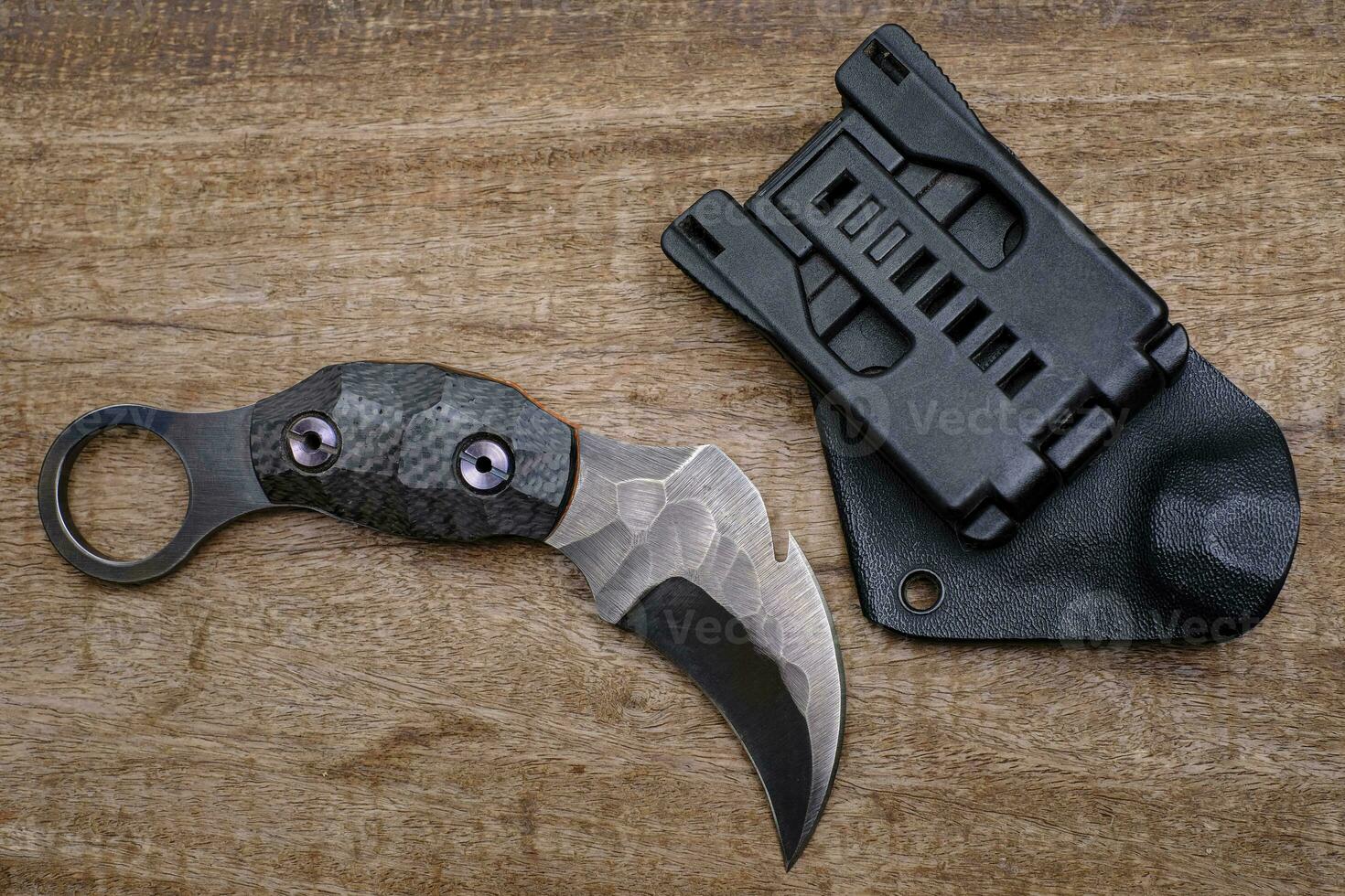 couteau karambit combattant tactique sur fond de bois photo