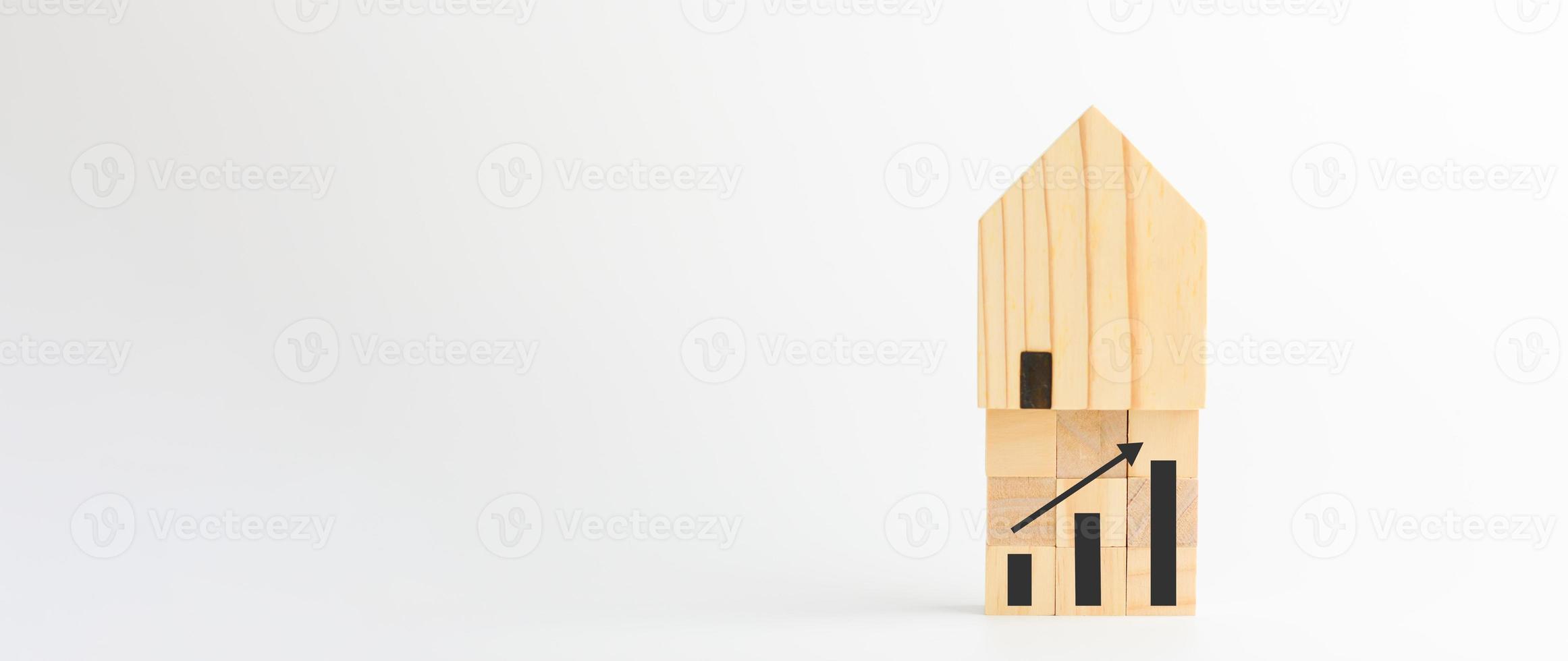 concept d'investissement immobilier et immobilier. maisons modèles en bois et graphiques sur blocs de bois cubiques, croissance immobilière dans le futur, finance, banque, prêt et commerce. photo