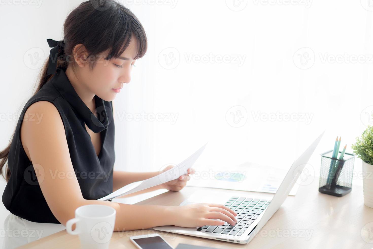 jeune femme asiatique travaillant et tapant avec un ordinateur portable au bureau, femme d'affaires à la recherche de données statistiques d'analyse de diagramme graphique de la finance, fille utilisant un ordinateur portable, croissance des bénéfices, concept d'entreprise. photo