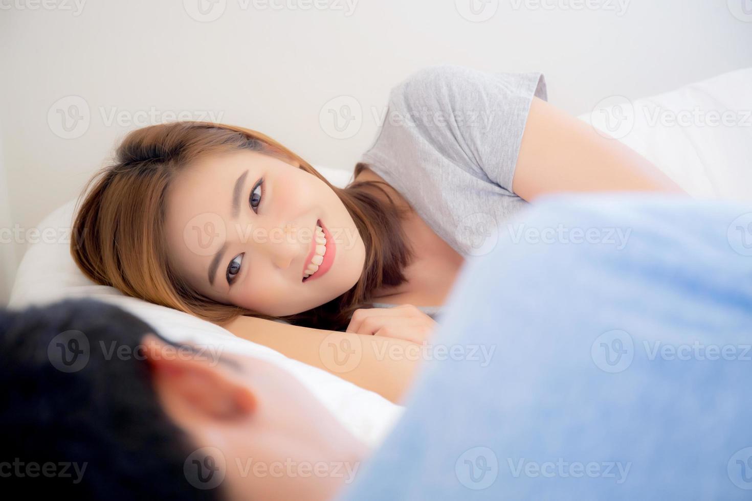 belle jeune femme asiatique à la recherche d'un homme, couple d'asie heureux et souriant couché amour romantique ensemble dans la chambre, mari et femme se détendent et lune de miel à l'heure du coucher. photo