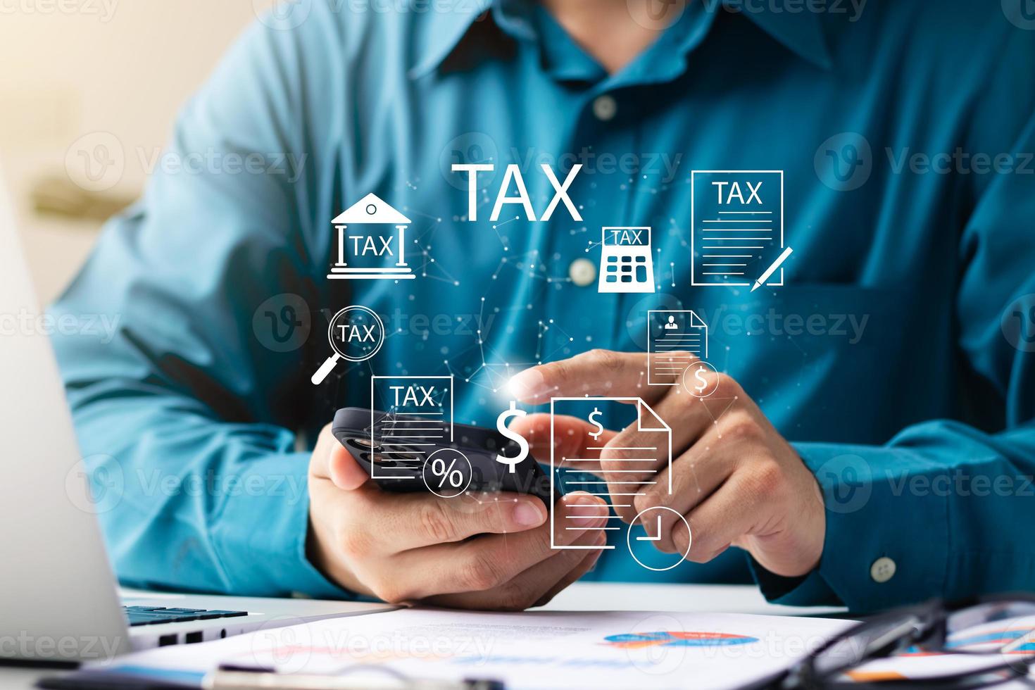 homme d'affaires utilisant son ordinateur portable et son smartphone pour remplir le formulaire de déclaration de revenus des particuliers en ligne pour le paiement de l'impôt, le calcul de l'impôt sur le revenu des particuliers. photo