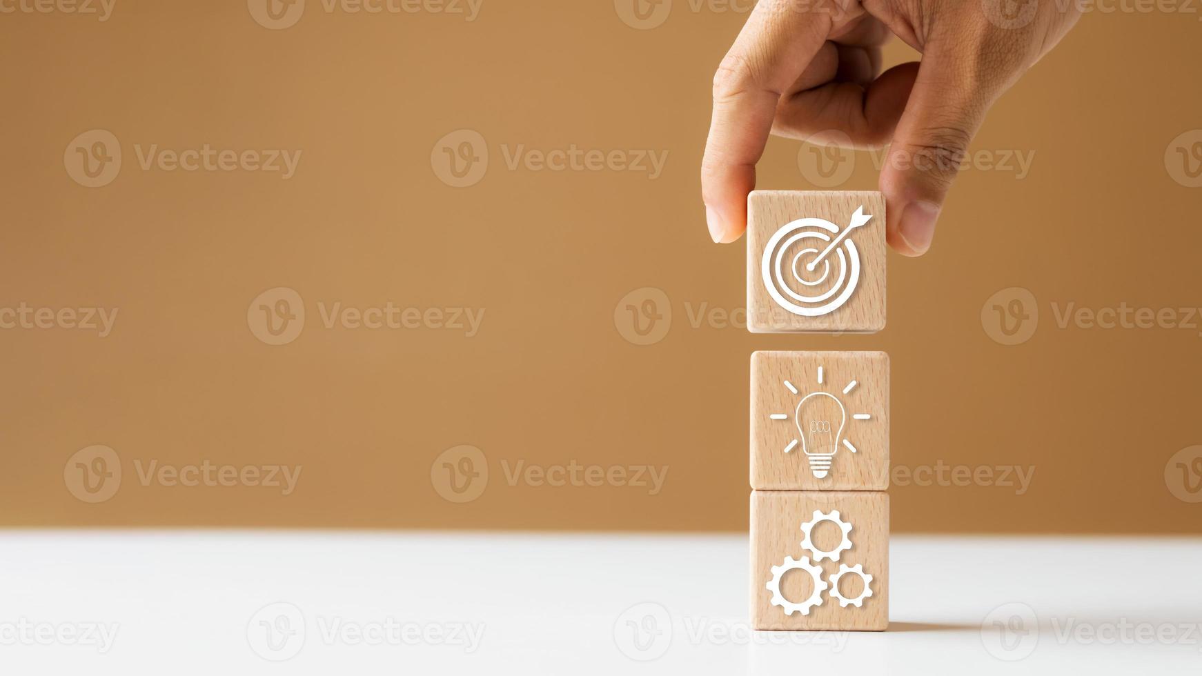 cube de bloc de bois à la main avec le développement de la stratégie de l'entreprise icône, le succès du concept et les objectifs commerciaux. photo