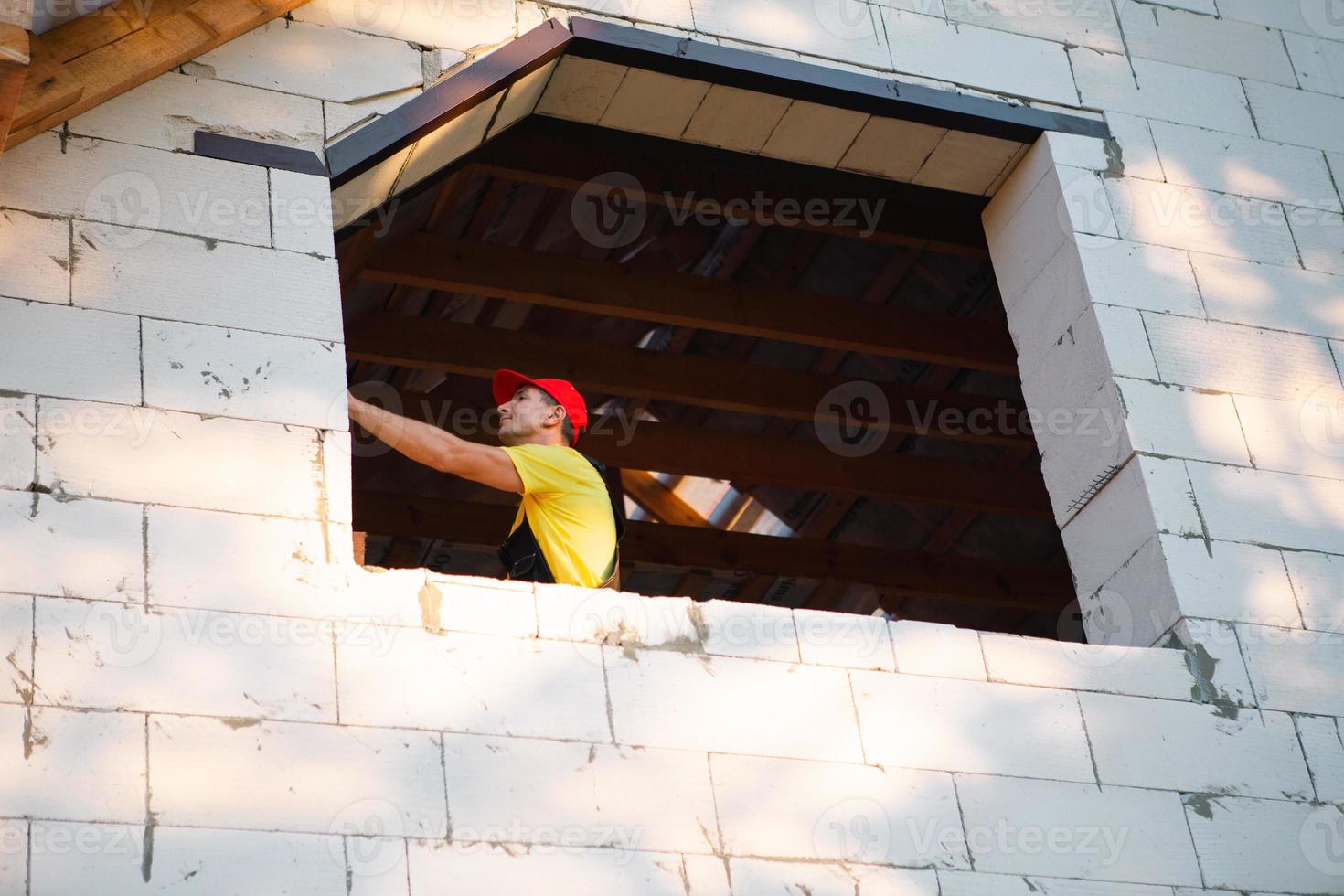 un ouvrier du bâtiment sur le chantier mesure la longueur de l