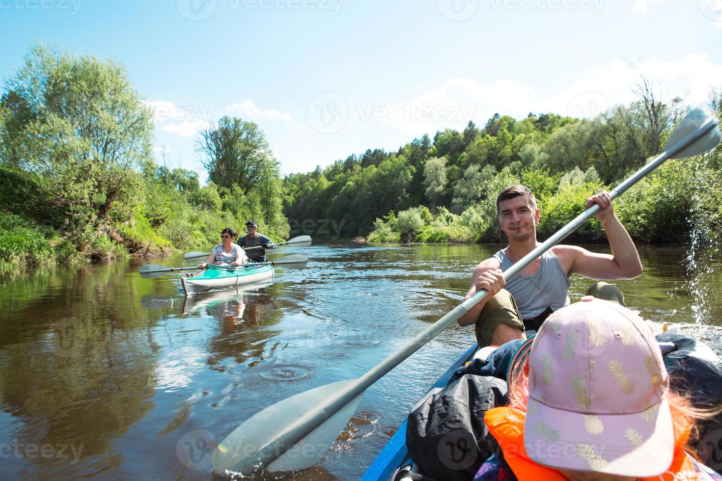 balade en kayak en famille. père et fille, et couple de personnes âgées senior et senior un bateau à rames sur la rivière, une randonnée aquatique, une aventure estivale. tourisme écologique et extrême, mode de vie actif et sain photo