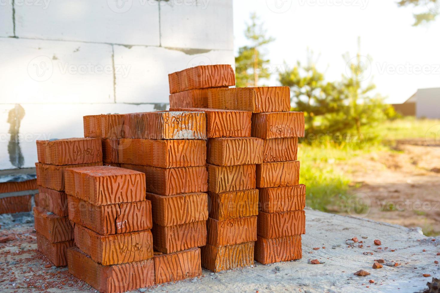 une pile de briques rouges sur un chantier de construction. matériaux de construction, livraison, entrepôt. copie espace photo