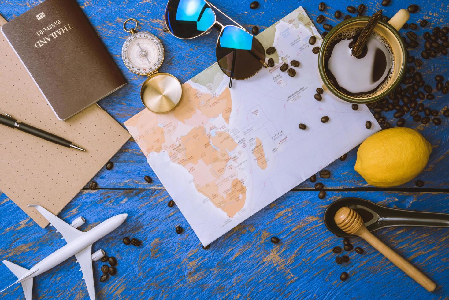 accessoires pour le voyageur sur le vieux fond sur la table en bois bleue. concept de voyage utilisant la carte du monde et la boussole ainsi que d'autres accessoires de voyage. café chaud et grains. été photo