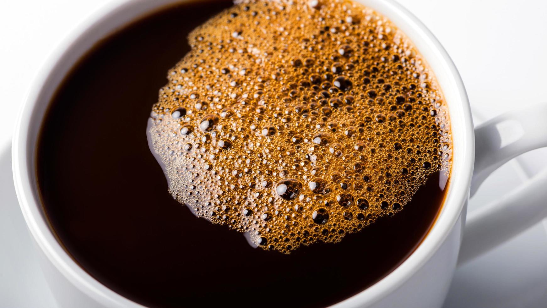 des bulles de café noir dans une tasse de café. photo