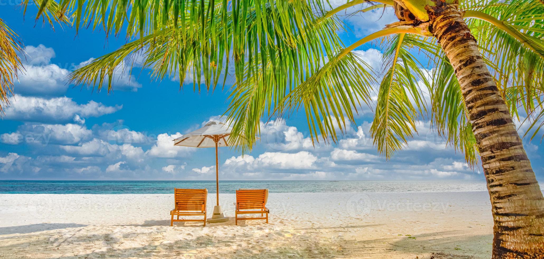 beau paysage d'île tropicale, deux chaises longues, chaises longues, parasol sous palmier. sable blanc, vue mer avec horizon, ciel bleu idyllique, calme et détente. hôtel balnéaire inspirant photo