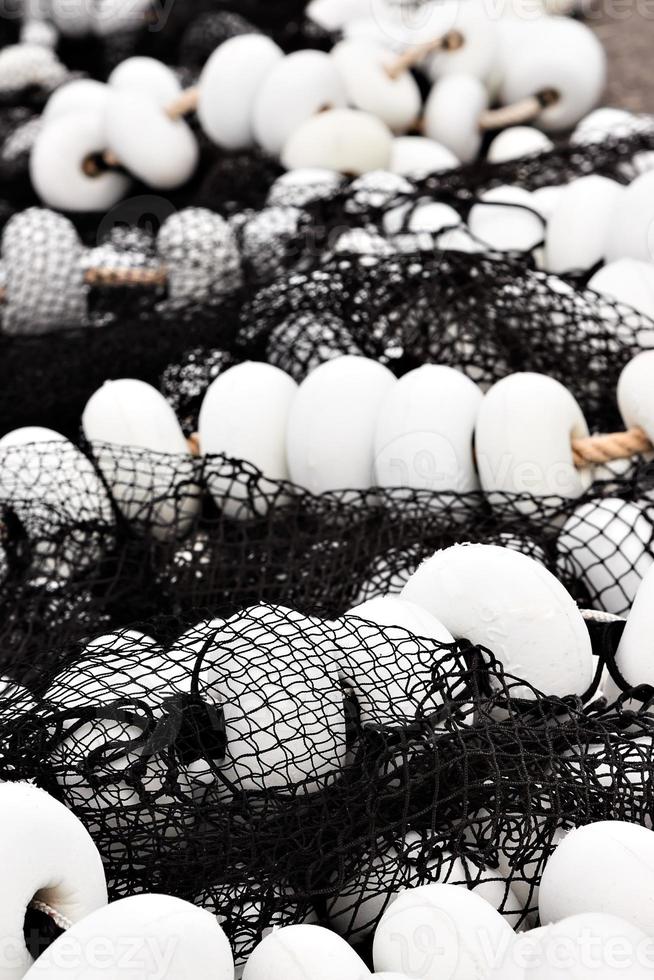 filet de pêche noir avec bouchons blancs dans le port de santona, cantabrie, espagne. image verticale. photo