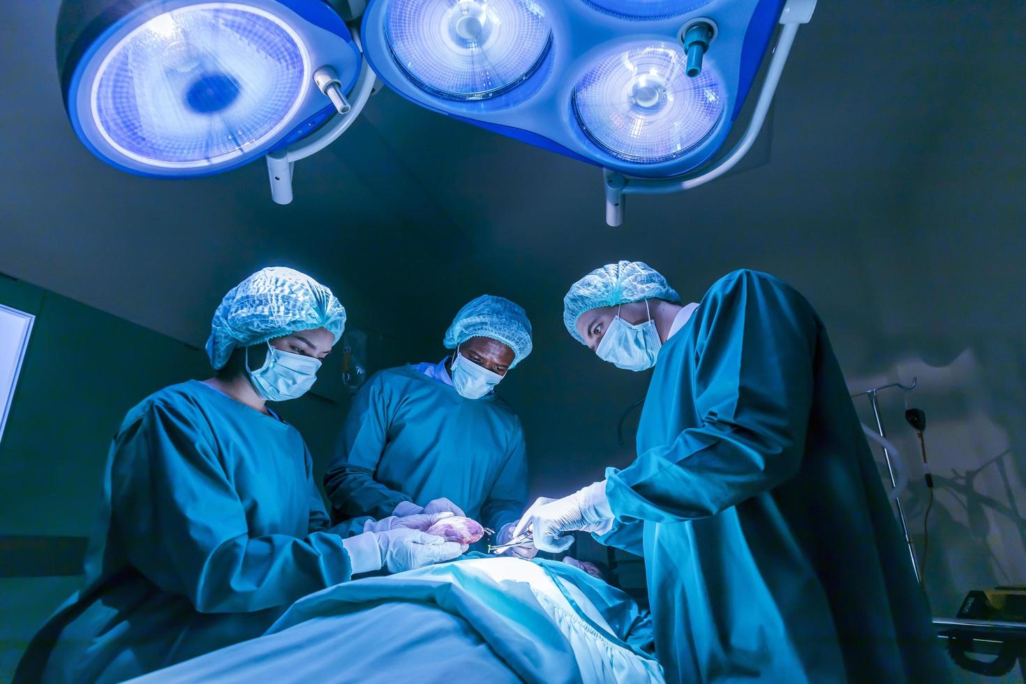 une équipe de médecins chirurgiens effectue une opération de chirurgie cardiaque pour un patient d'un donneur d'organes afin de sauver plus de vie dans la salle d'opération d'urgence photo