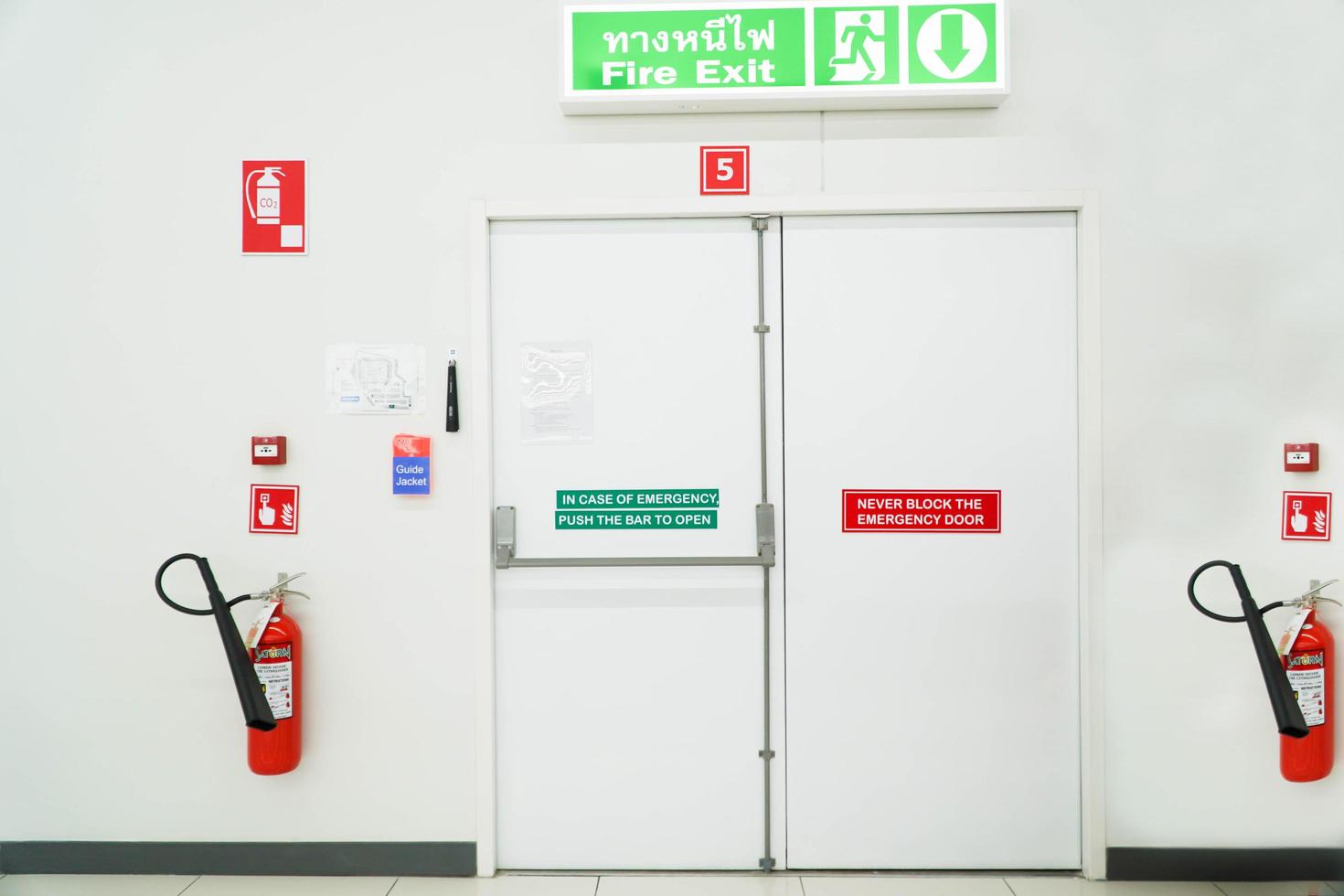 sortie de secours du bâtiment avec panneau de sortie et extincteur. photo