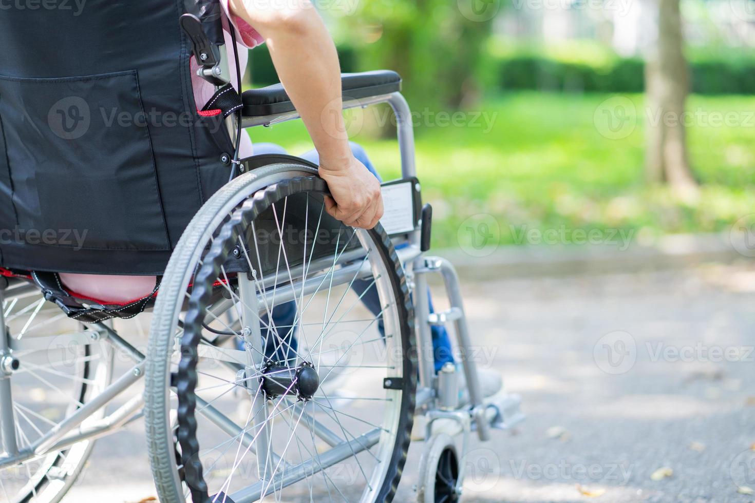 image d'une femme asiatique d'âge moyen assise sur un fauteuil roulant photo