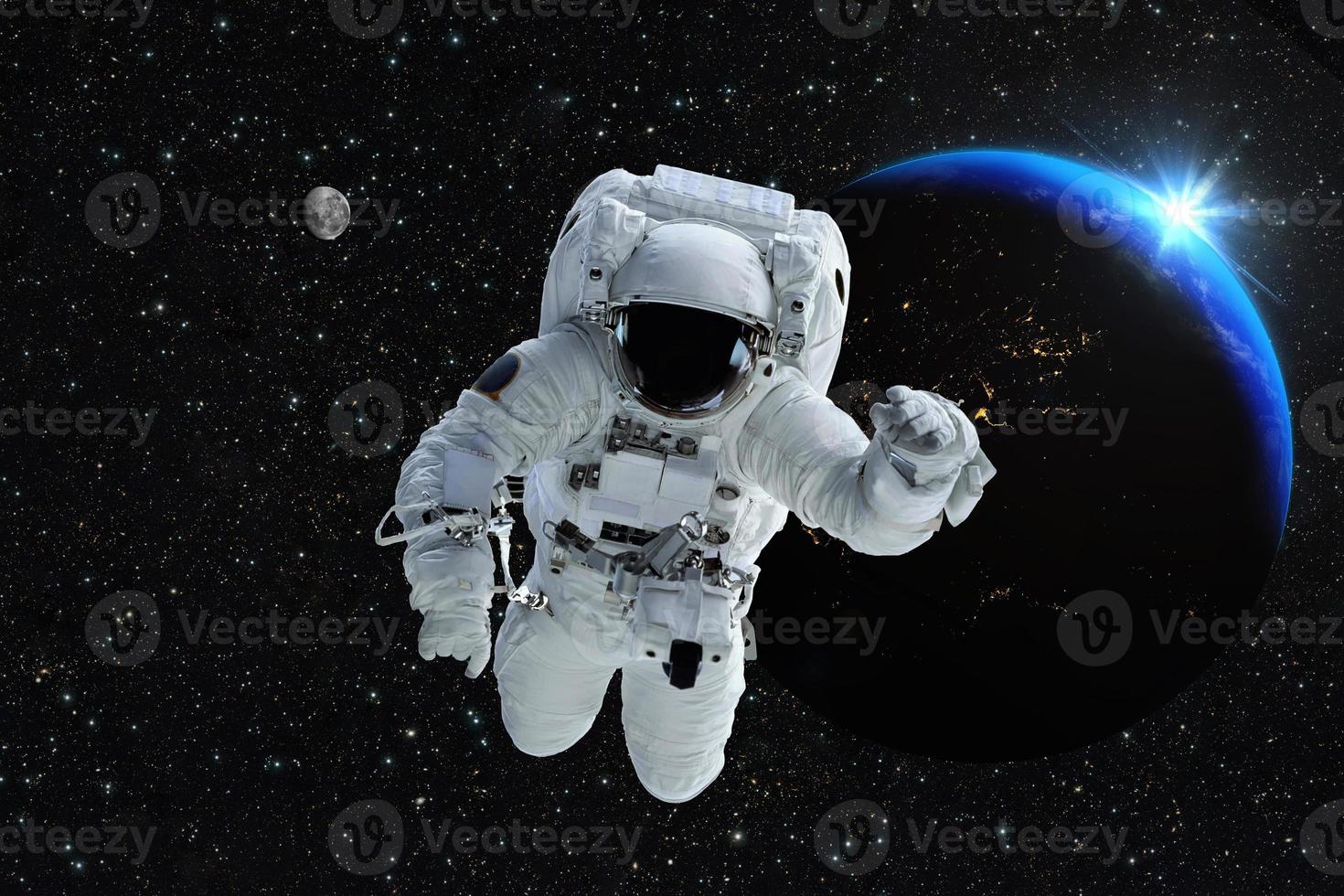 astronaute spaceman espace extra-atmosphérique personnes planète terre lune. beau lever de soleil bleu. éléments de cette image fournis par la nasa. photo