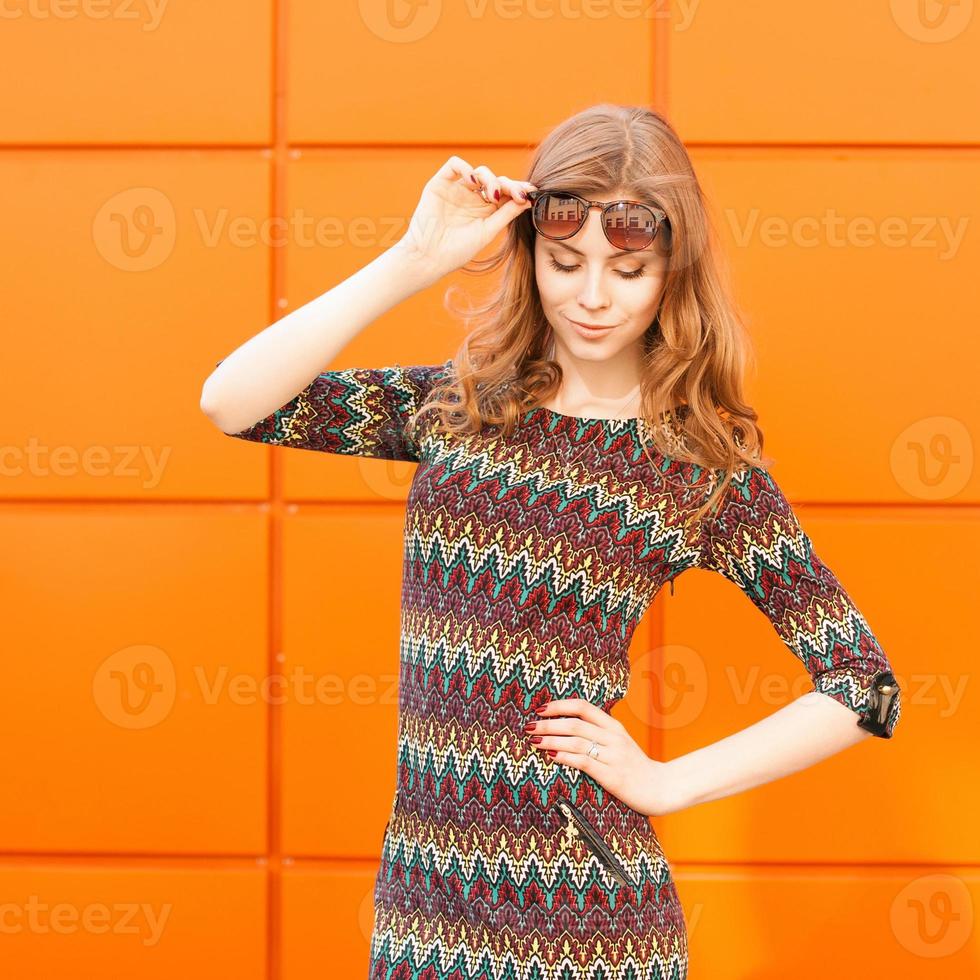 portrait de beauté jolie femme dans l'été de la ville près d'un mur coloré. photo