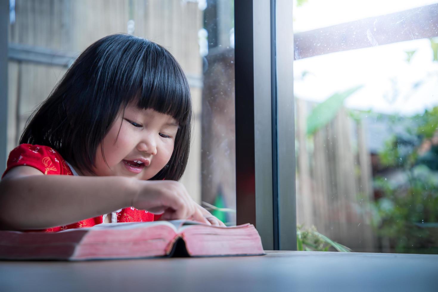 petite fille lisant la bible à la maison, la foi pure de l'enfant photo