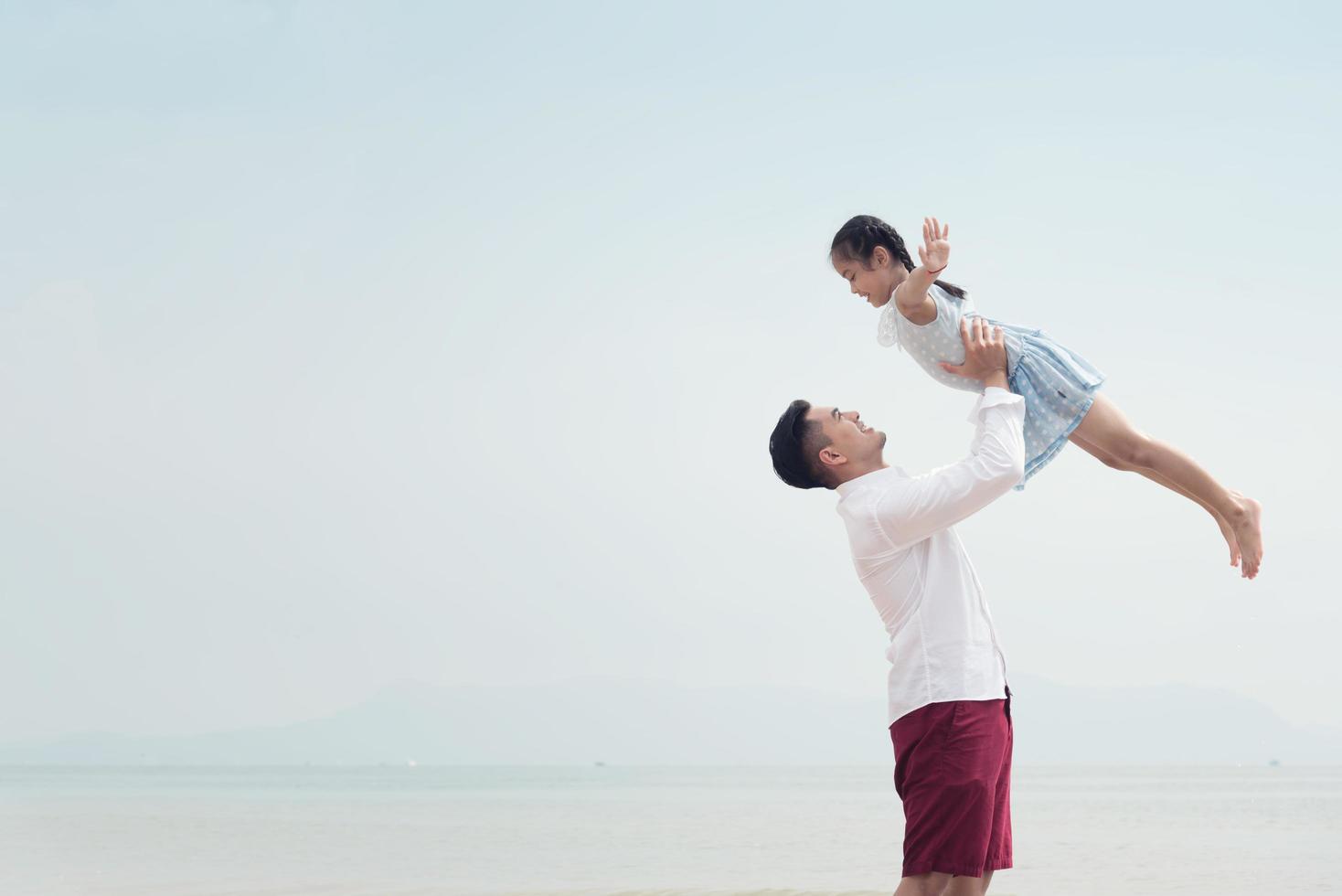 famille heureuse sur la plage courir et sauter au coucher du soleil photo