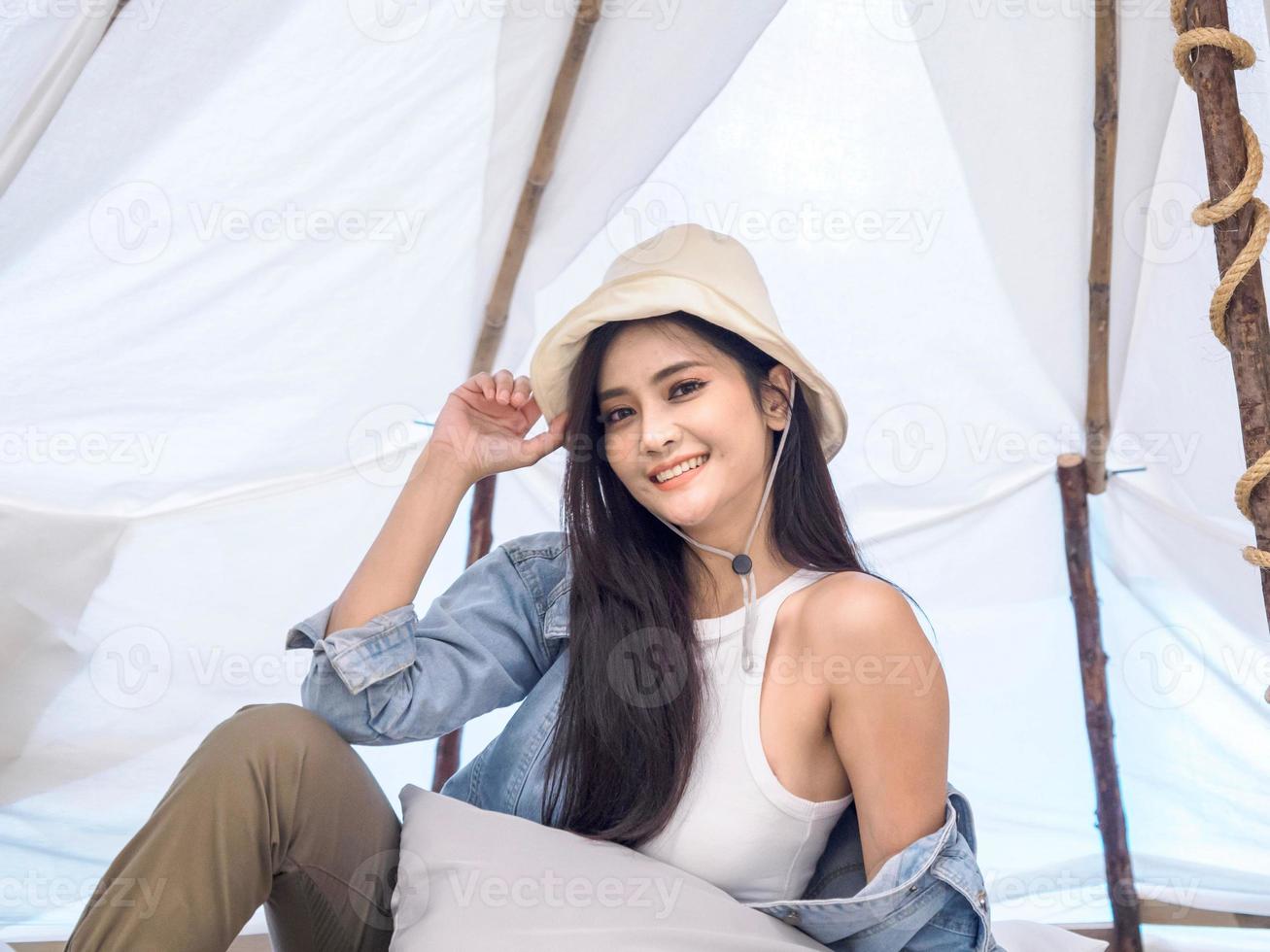 portrait belle jeune fille femme asiatique joli sourire une personne seule assise sur une chaise camping avec teble fleur dans un vase lanterne rouge voyage voyage devant tente liberté se détendre heureux profiter en vacances photo