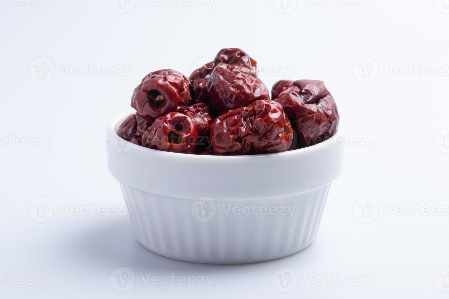 jujube chinois séché dans une tasse sur fond blanc. image isolée. photo