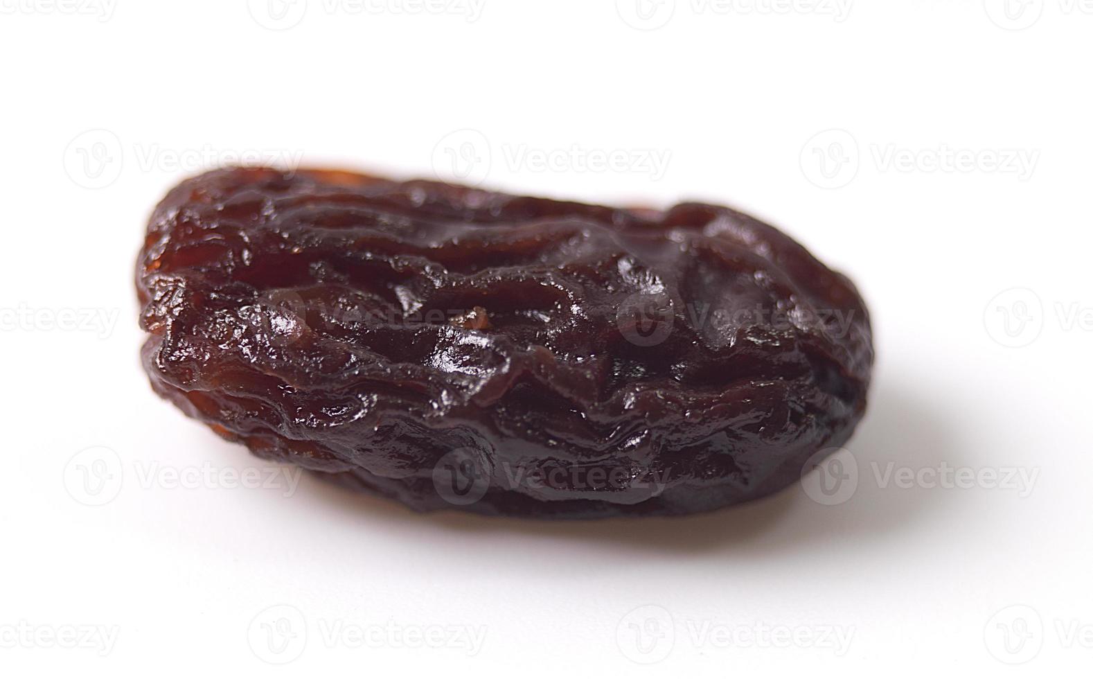 Raisins secs noirs sur fond blanc photo