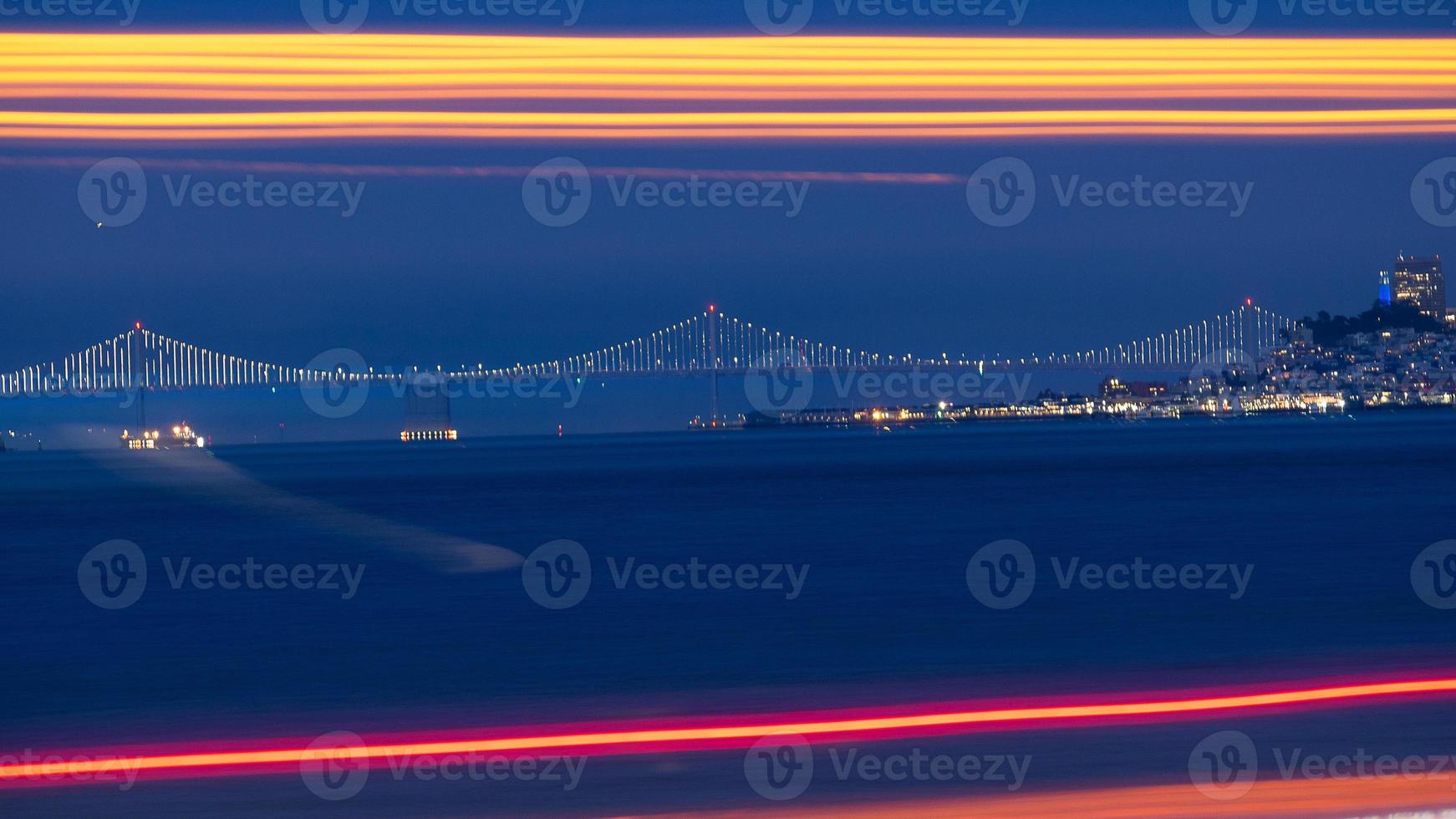 Bay Bridge au loin avec des feux de circulation à longue exposition en premier plan photo