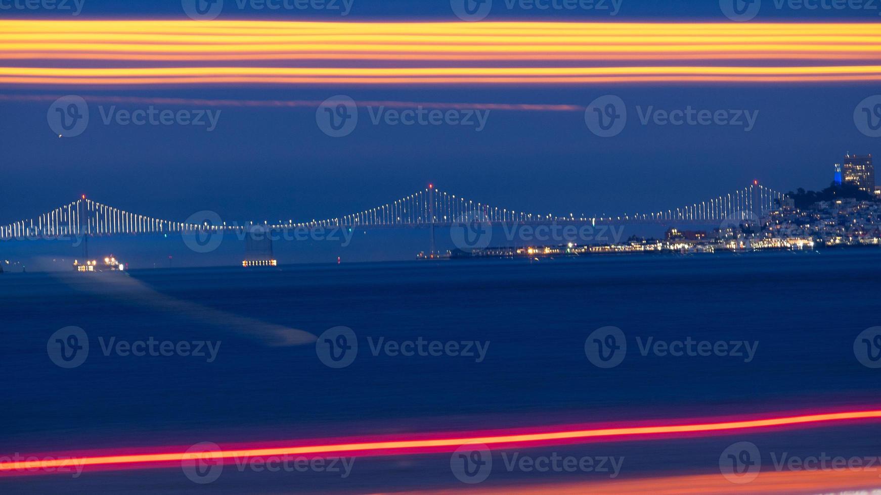 Bay Bridge au loin avec des feux de circulation à longue exposition en premier plan photo