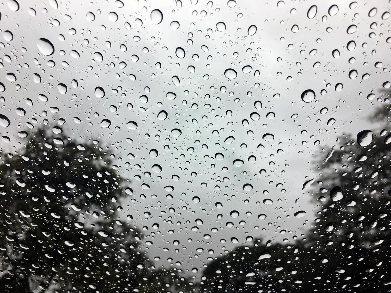 goutte de pluie sur le verre de la voiture avec fond de texture abstraite avec lumière de jante, lumière du soleil photo