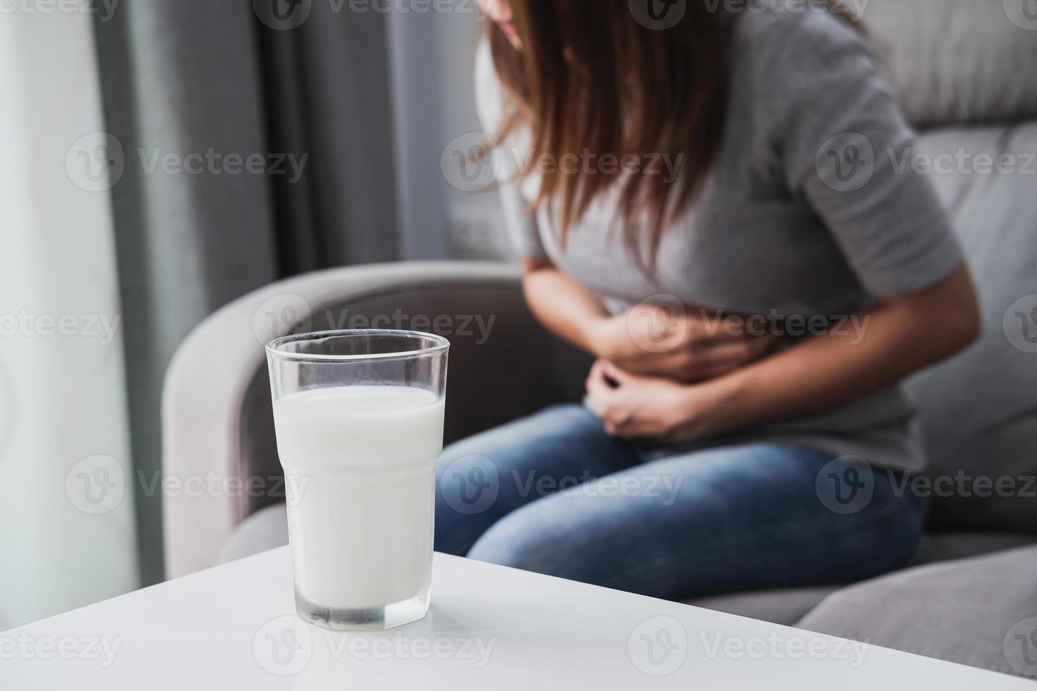 femme ayant mal au ventre avec un verre de lait, intolérance au lactose, concept de soins de santé photo