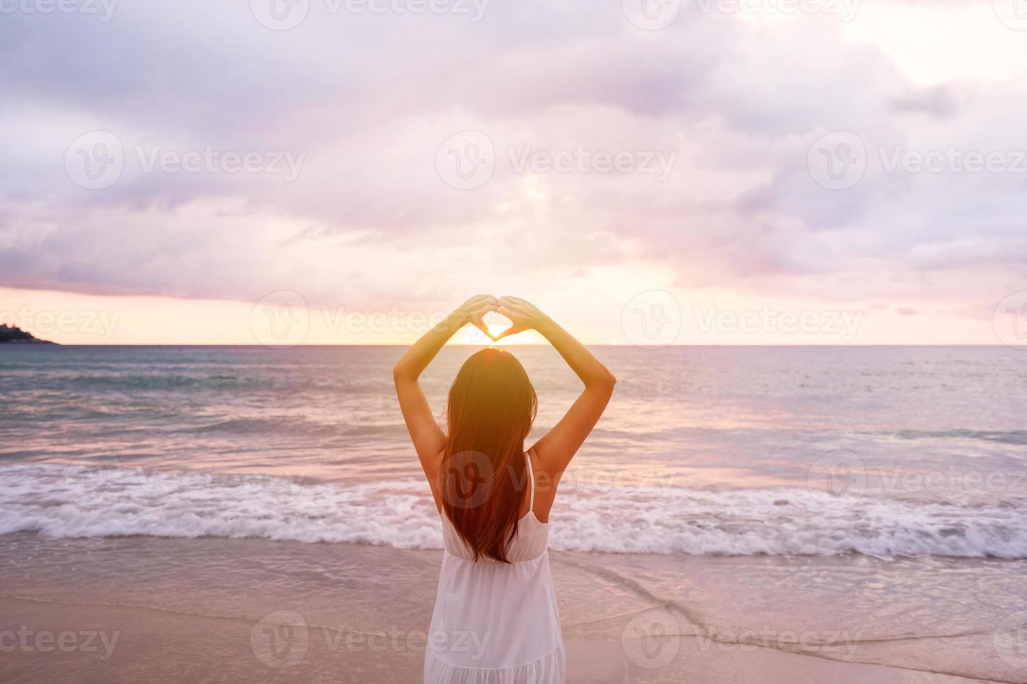 jeune femme voyageuse marchant et appréciant le beau coucher de soleil sur la plage tranquille, voyageant sur le concept de vacances d'été photo