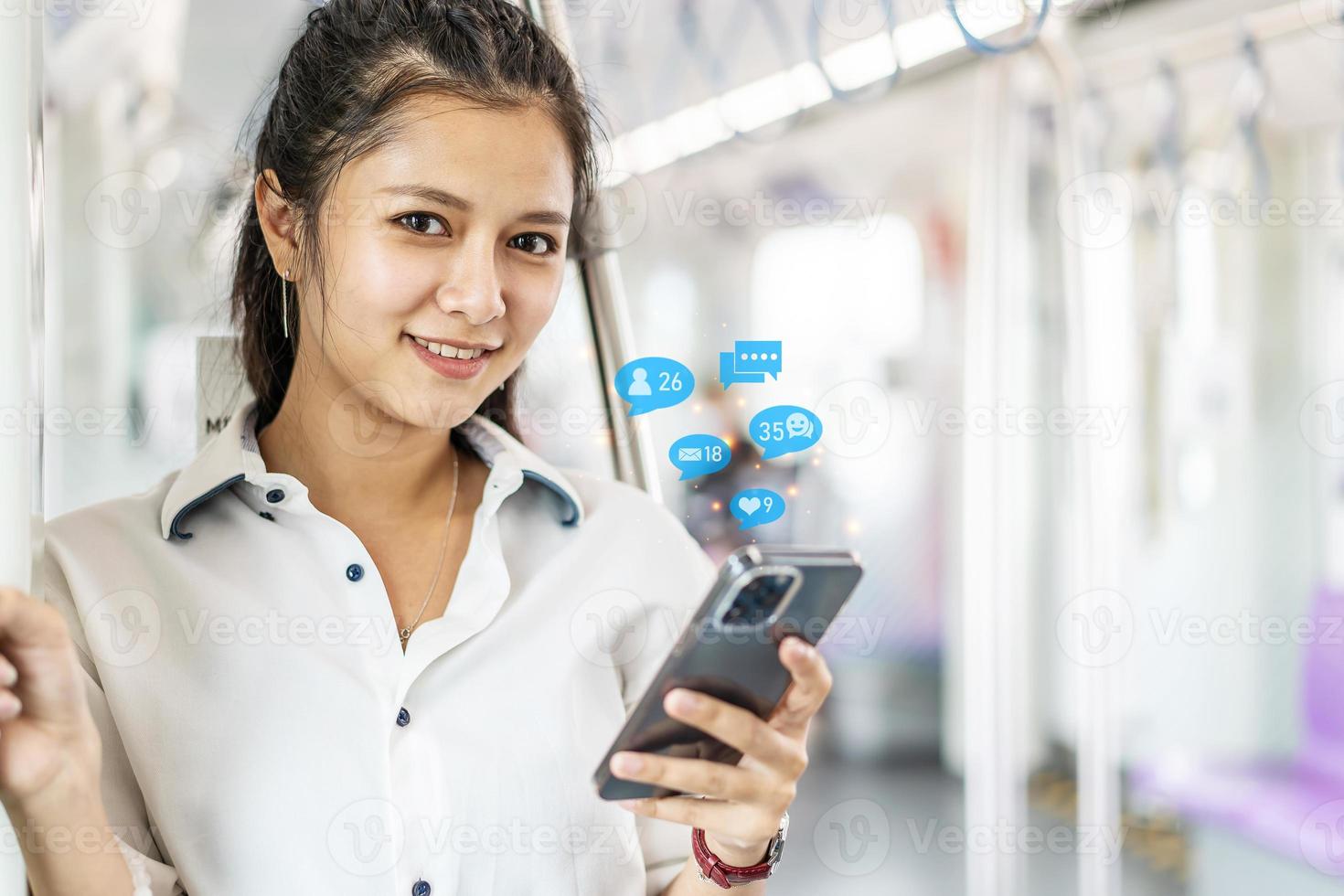 jeune femme asiatique passagère debout et utilisant un téléphone portable à l'intérieur d'une voiture vide de métro ou de train aérien, loisirs et vie quotidienne photo