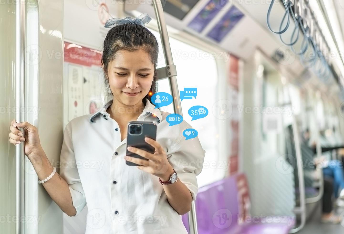 jeune femme asiatique passagère debout et utilisant un téléphone portable à l'intérieur d'une voiture vide de métro ou de train aérien, loisirs et vie quotidienne photo