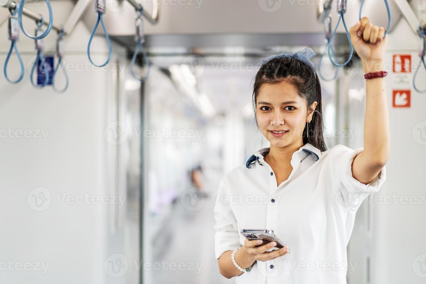 jeune femme asiatique passagère debout et utilisant un téléphone portable à l'intérieur d'une voiture vide de métro ou de train aérien, loisirs et vie quotidienne photo