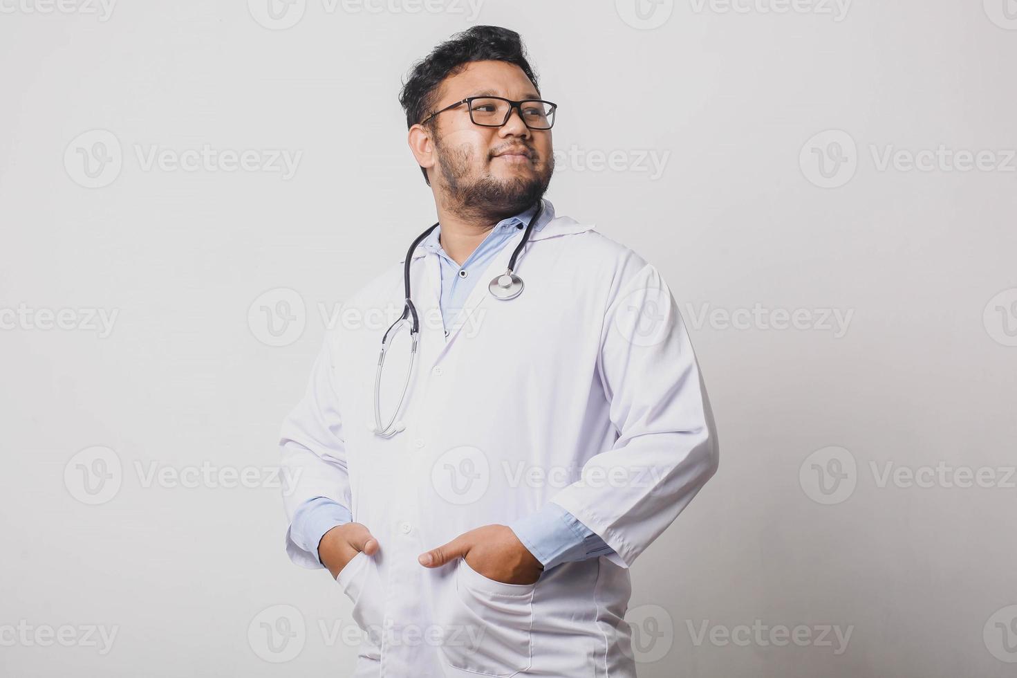 Médecin homme réfléchi élégant avec les mains dans les poches isolé sur fond blanc photo