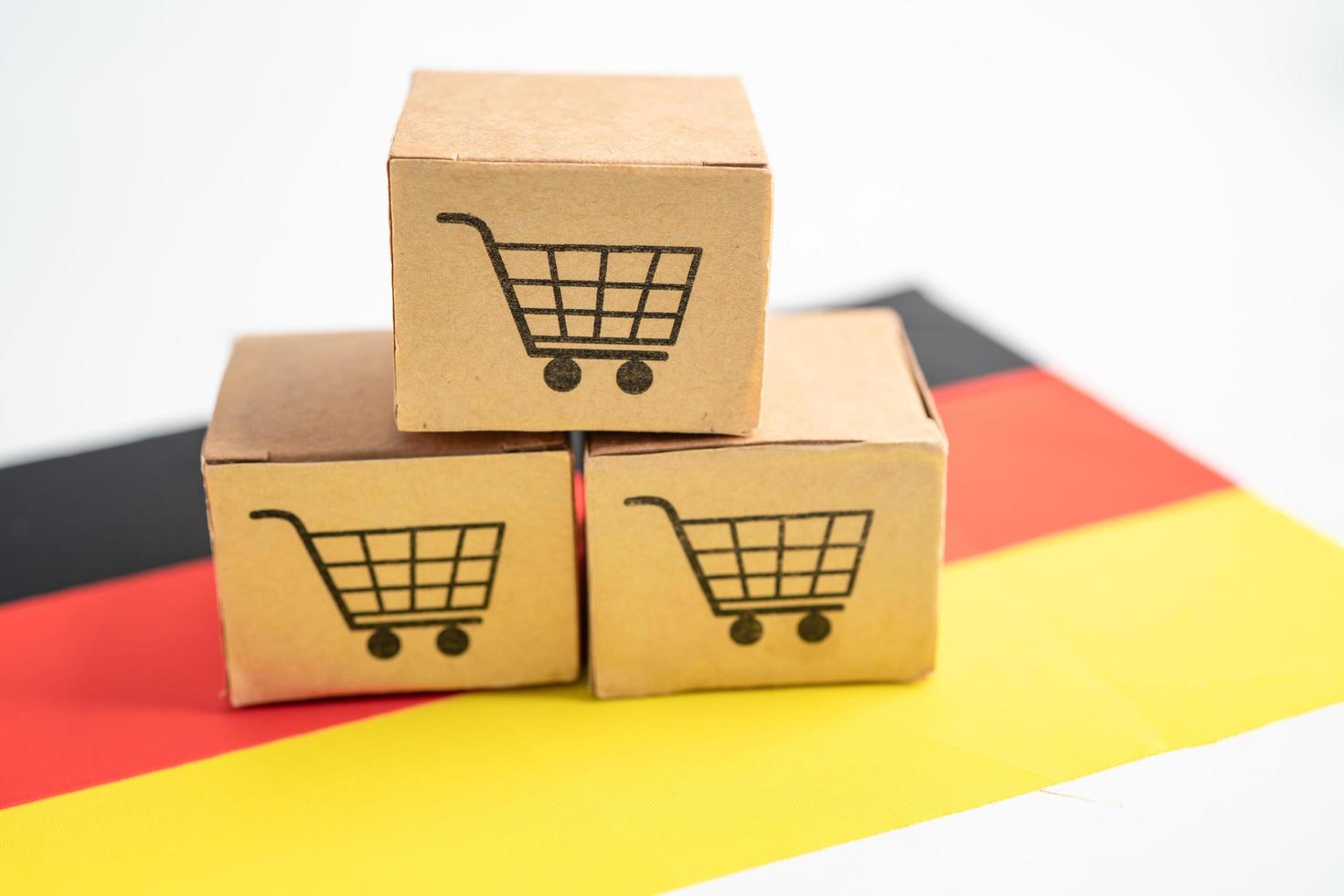 boîte avec logo du panier d'achat et drapeau de l'allemagne, importation, exportation, achats en ligne ou e-commerce, service de livraison de financement, expédition de produits, commerce, concept de fournisseur. photo