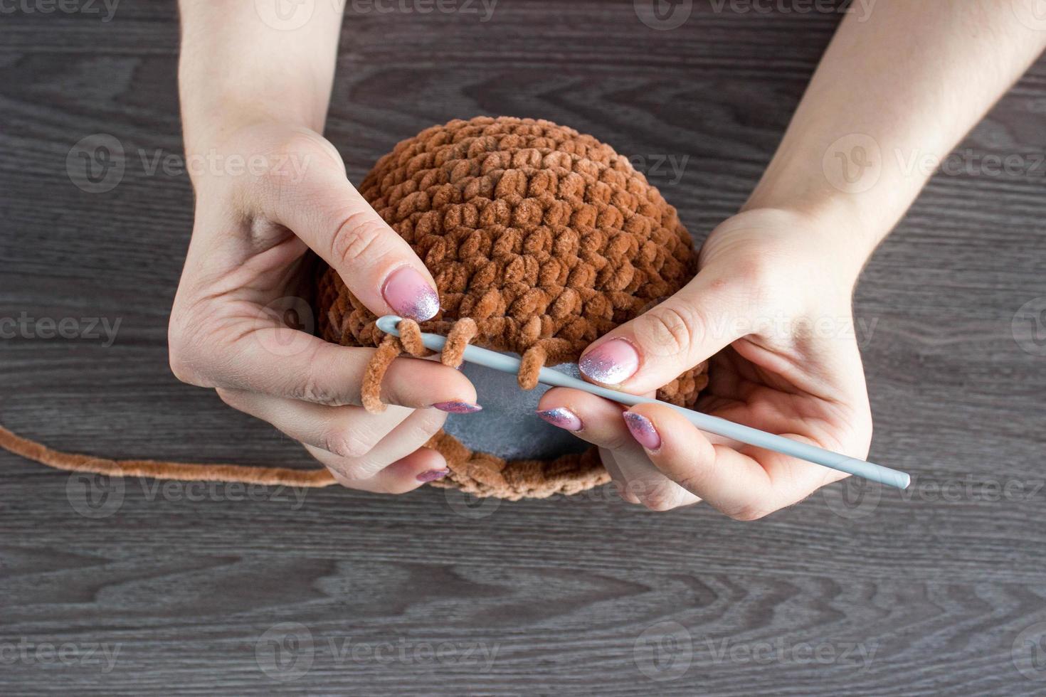 le processus de tricotage de jouets pour enfants à partir de fils en peluche. tête à tricoter. Fait main photo