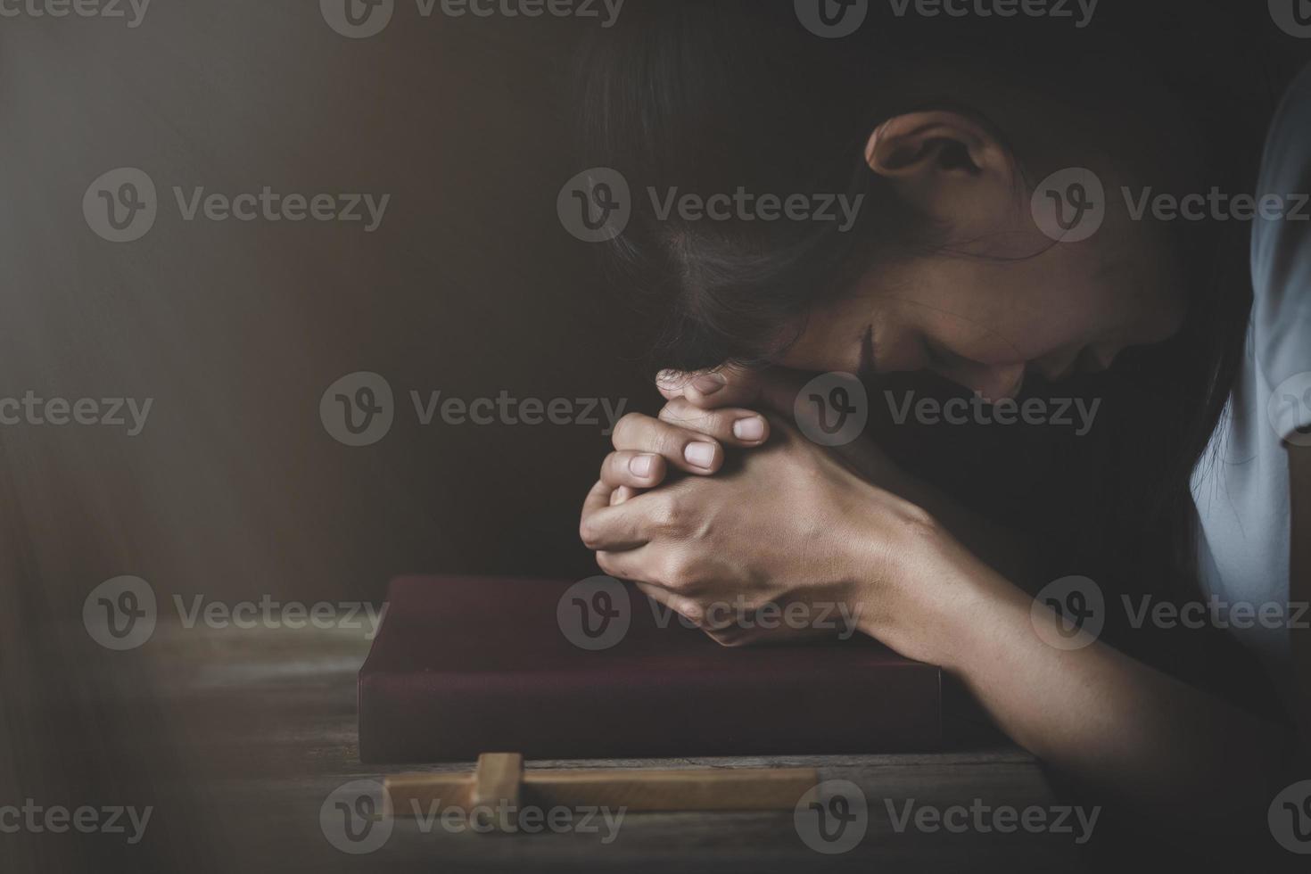 la main posée sur la bible avec la tête baissée. Prier Dieu. prier pour les croyances spirituelles. le pouvoir de l'espoir ou de l'amour et de la loyauté. foi en la bonté. photo