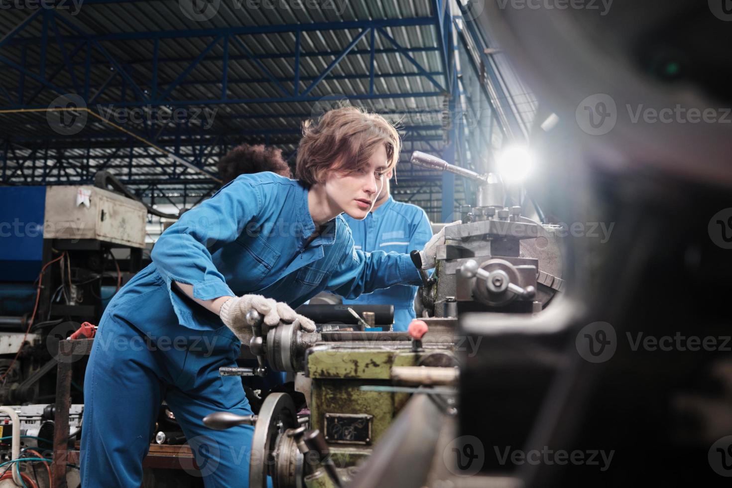 une jeune ingénieure professionnelle blanche de l'industrie travaille en uniforme de sécurité avec des outils de précision pour la métallurgie, des tours mécaniques et un atelier de pièces de rechange dans l'usine de fabrication d'acier. photo