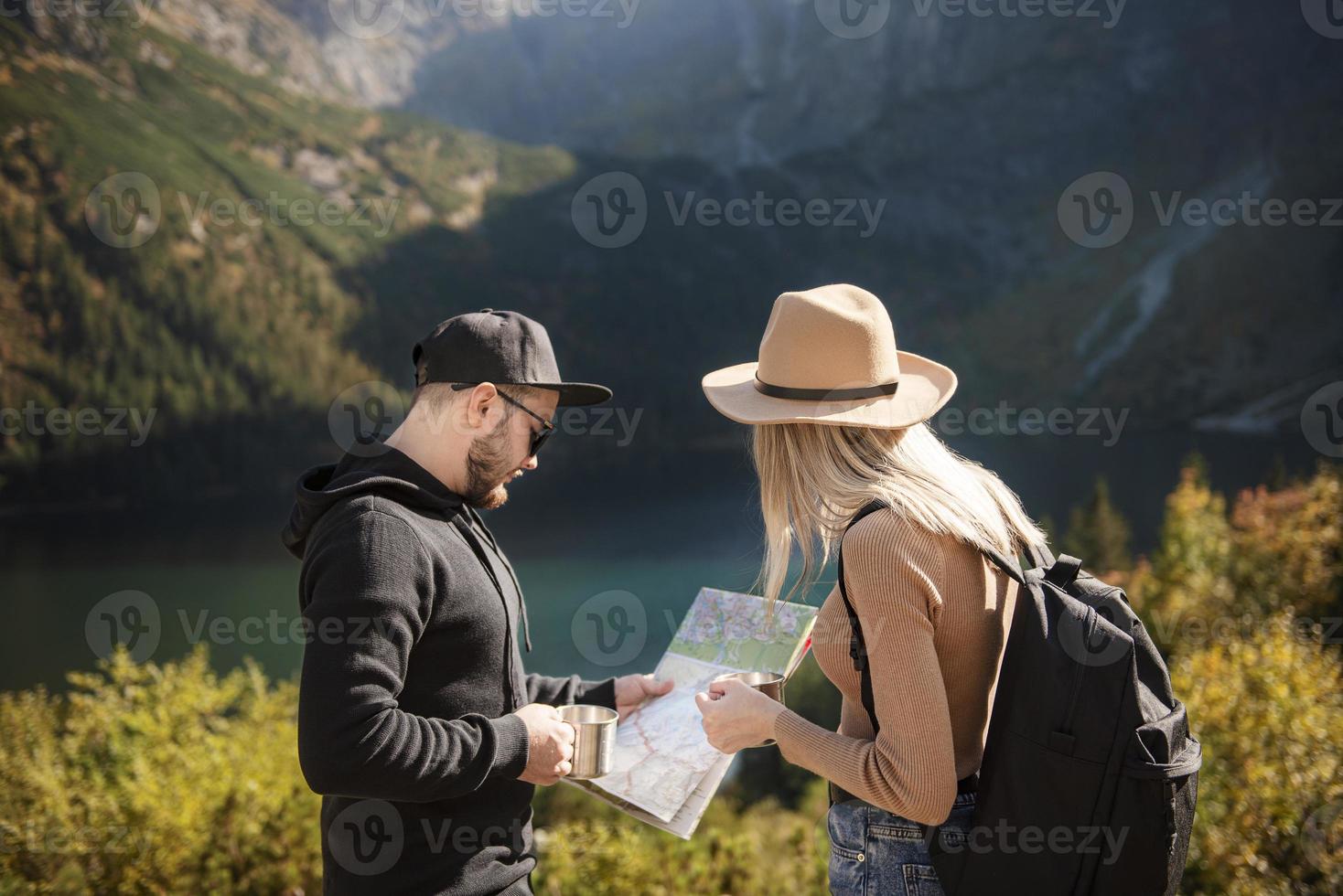 jeune couple de touristes, homme et femme, sur un chemin de randonnée dans les montagnes photo