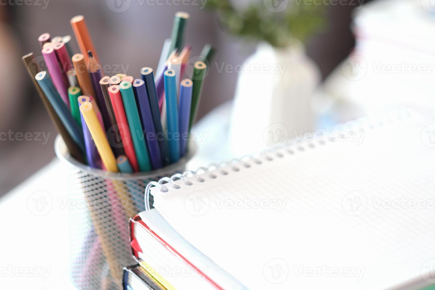 retour à l'école 2022, crayons de couleur. vue recadrée d'une pile de livres et d'un cahier ou d'un bloc-notes photo