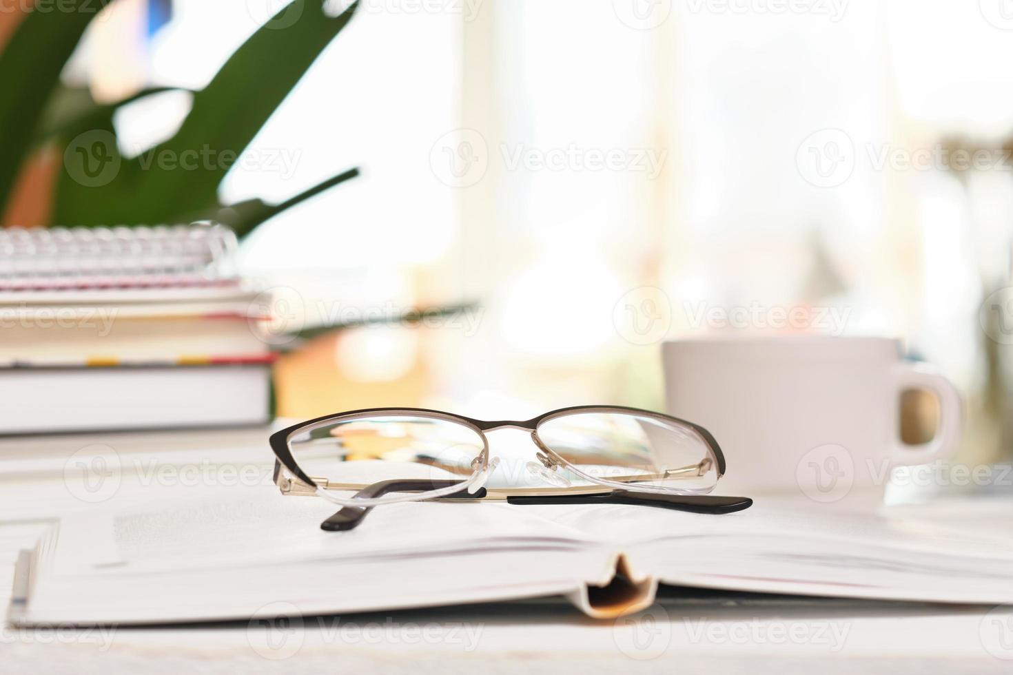 lunettes et livres sur une table et une tasse de café. concept de cognition et de recherche. l'apprentissage scolaire, la science et la méthodologie. bibliothèque du campus universitaire. photo